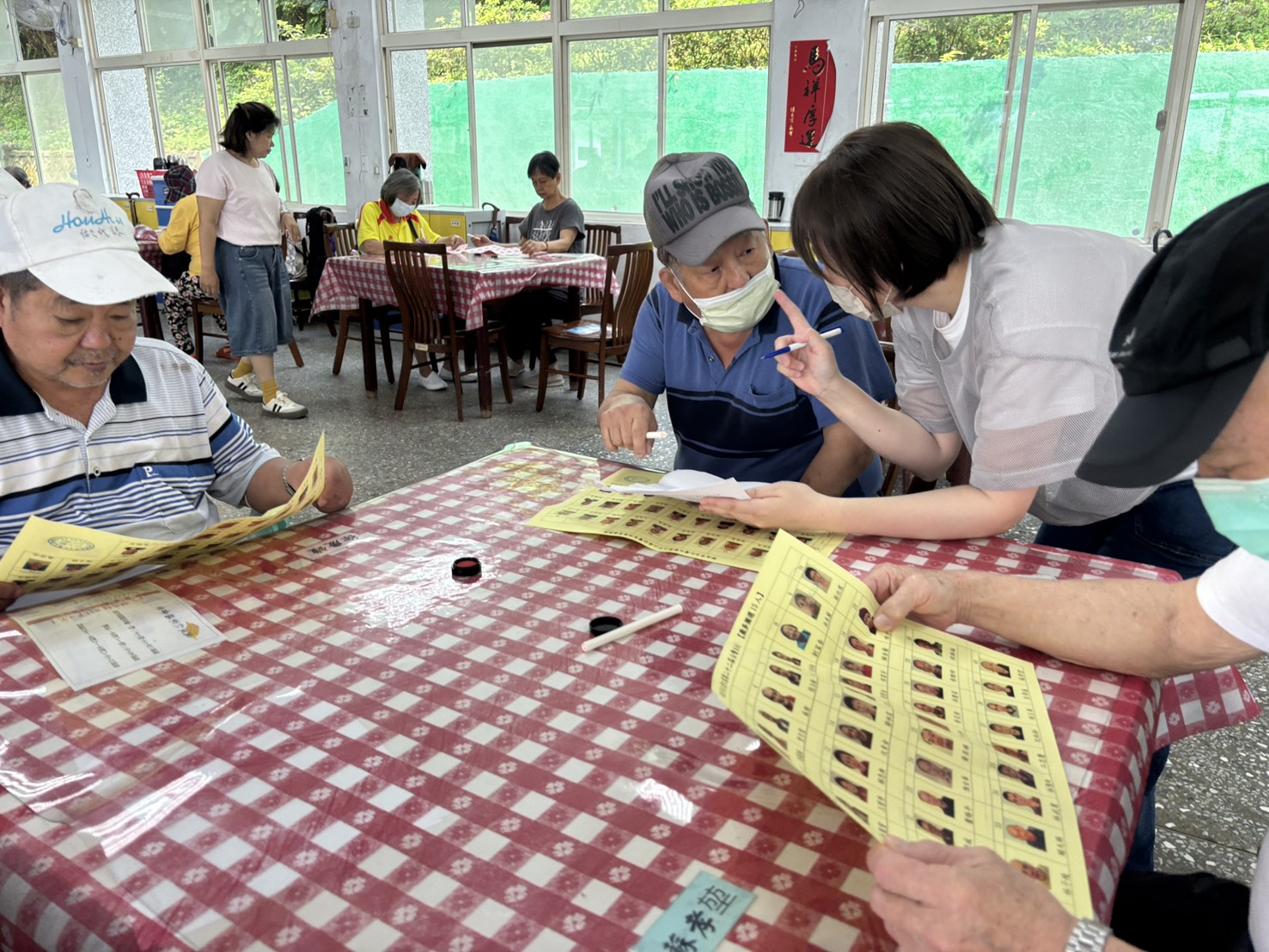 仁家舉行自治區長票選，住民仔細端詳選票，有不清楚之處，由工作人員予以說明。