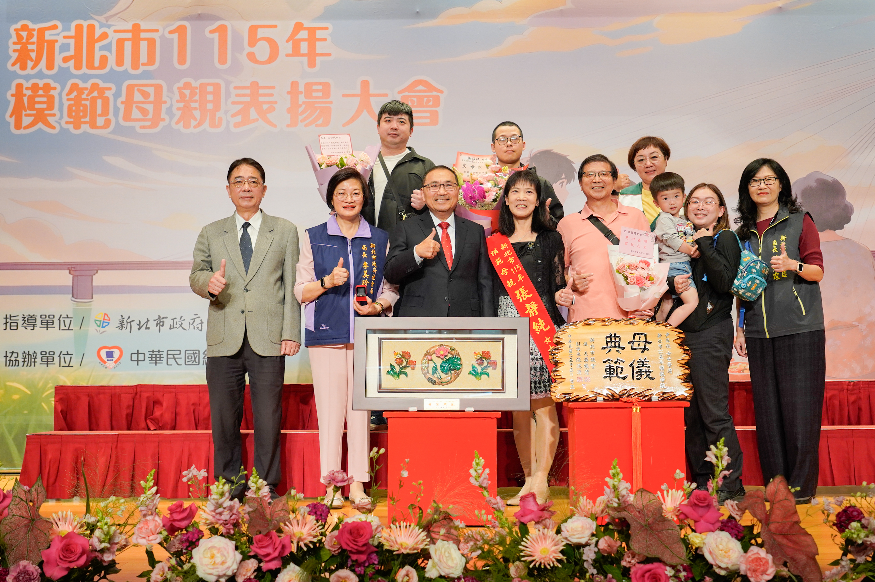 張靜純獲得今年模範母親，接受侯友宜市長表揚，她曾照顧3年多的小明（後排中）特地趕來為媽媽獻花祝福。