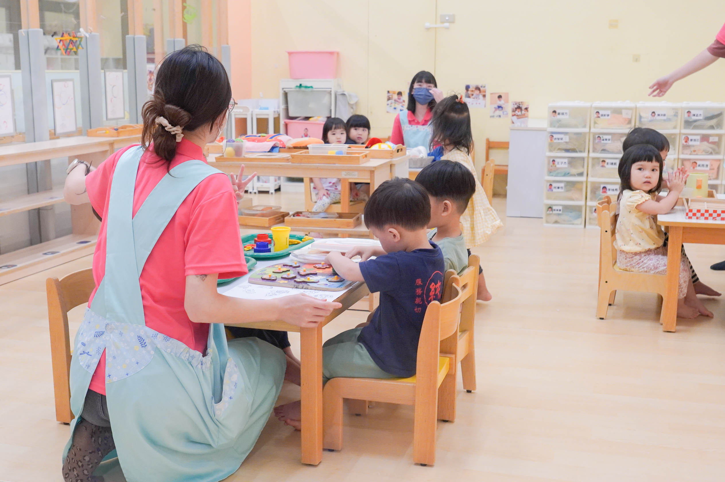 新北公托幼兒在保育員的帶領下 專心玩拼圖