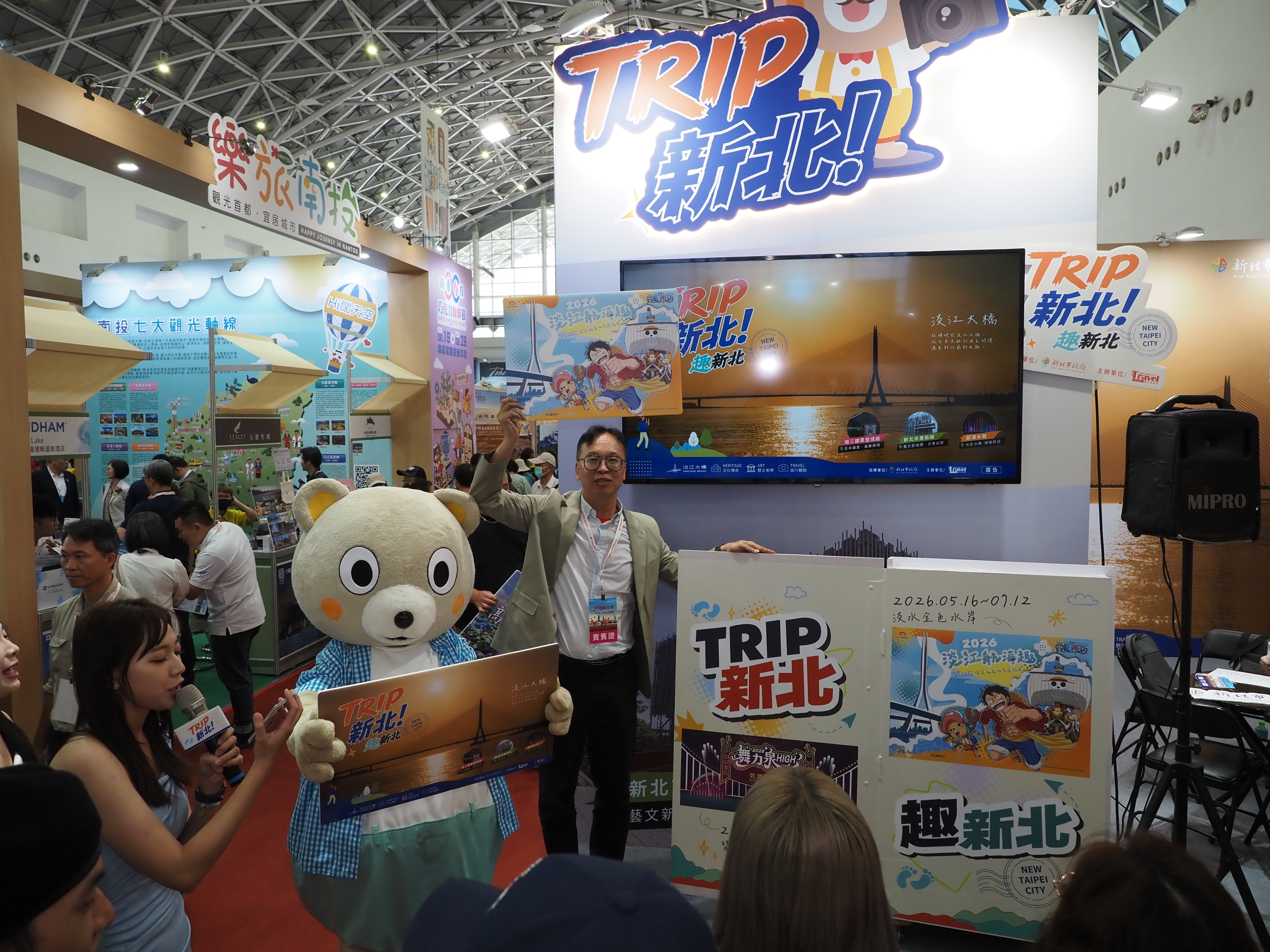 新北市觀光旅遊局長楊宗珉攜手吉祥物新北小客，熱情出席高雄國際旅展，為新北館站台造勢並推廣最新旅遊活動。