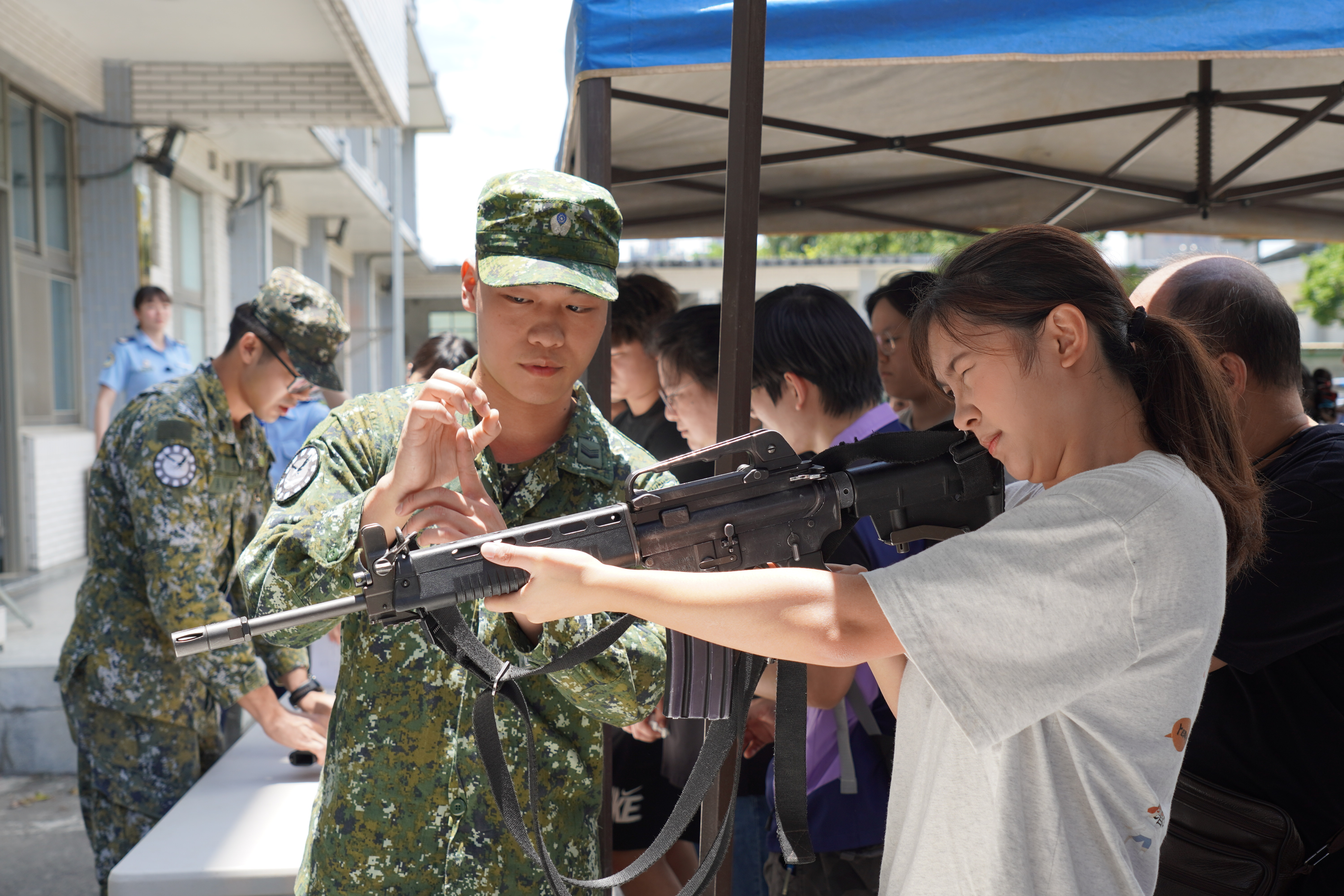 參觀空軍憲兵中隊讓青年體驗拿槍。