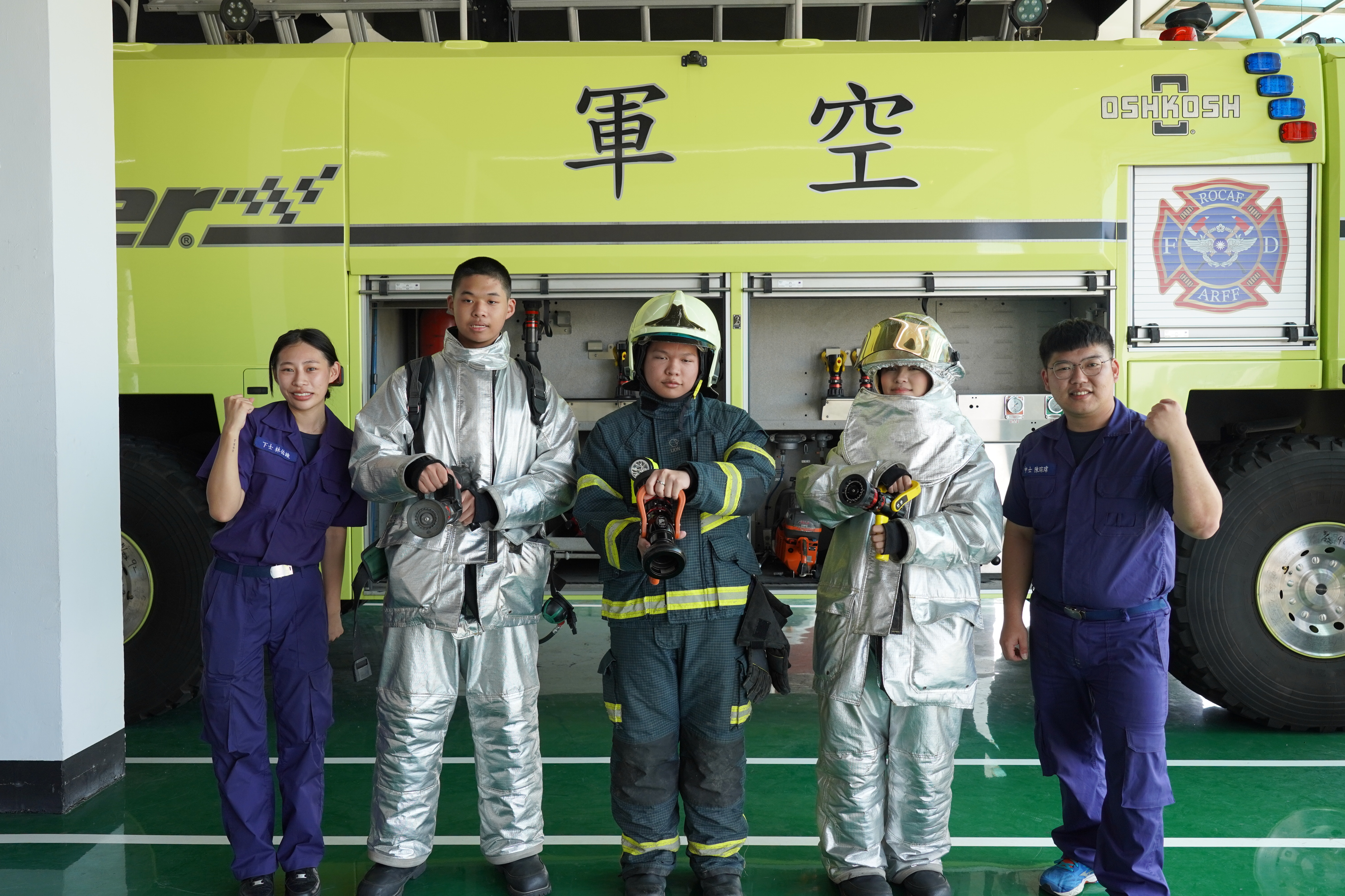 參訪空軍松山基地指揮部消防分隊，青年初次穿上消防服體驗裝備之沉重與不易，直呼體驗有趣且印象深刻。