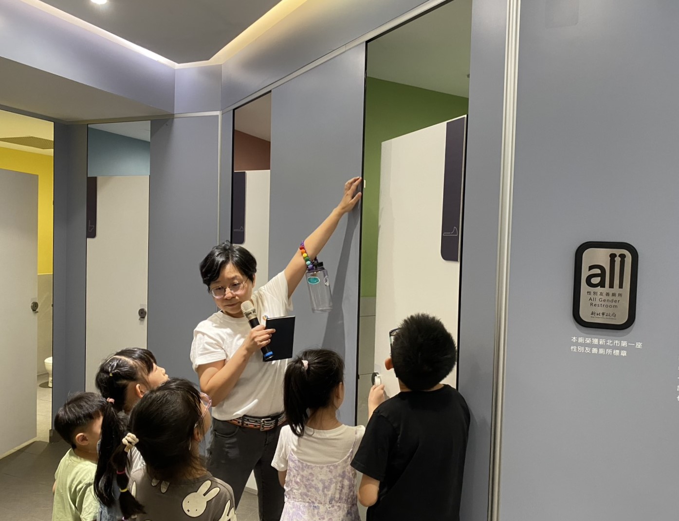 台灣伴侶權益推動聯盟秘書長簡至潔向孩子導覽性別友善廁所。