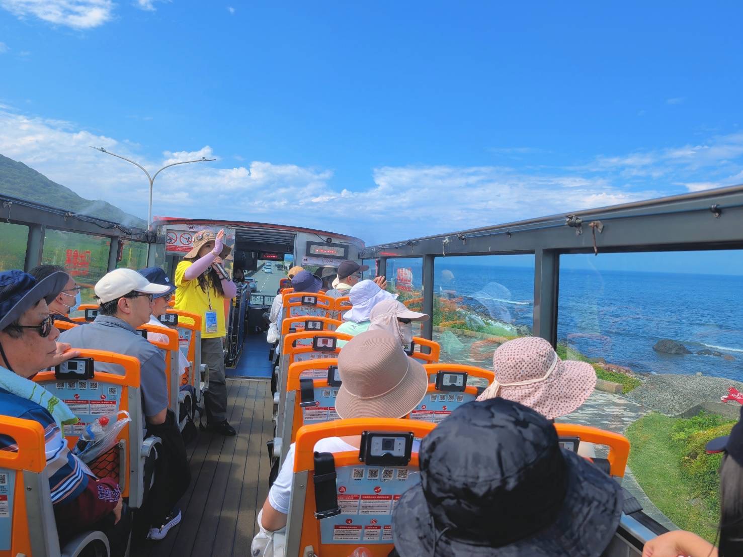  民眾搭乘敞篷景觀雙層巴士，從高處飽覽北海岸絕美海景。