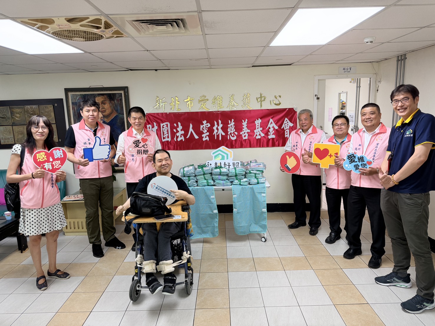  雲林慈善基金會捐贈愛維養護中心一批市值6萬元的圍兜兜，左3為基金會董事長林進忠