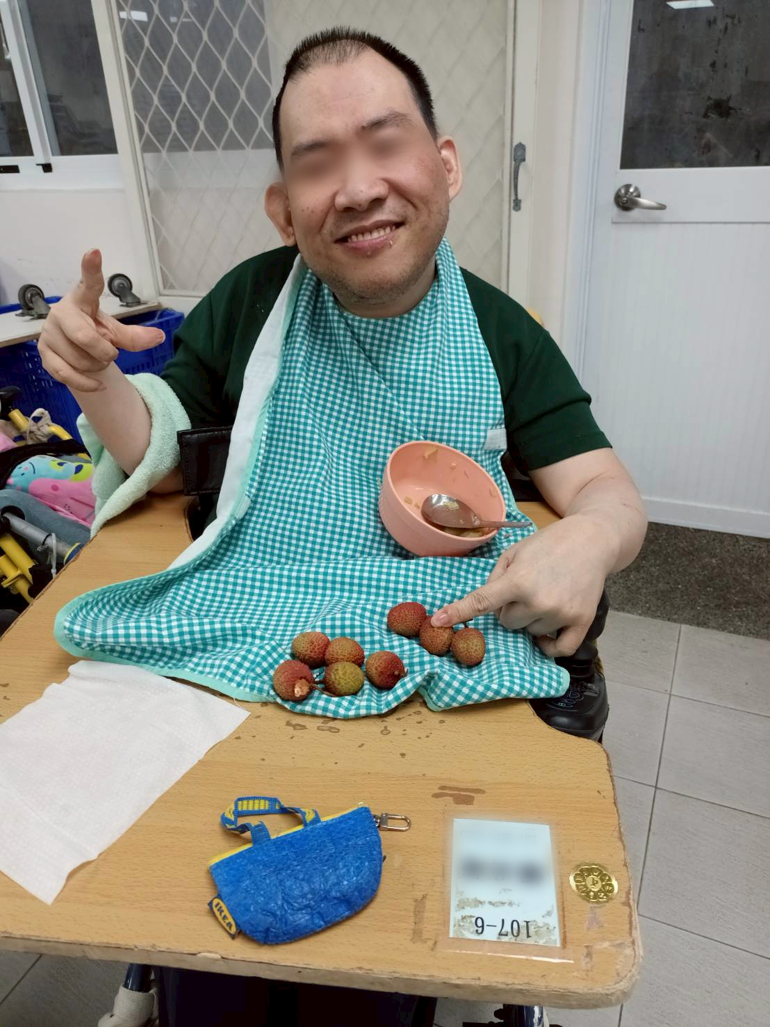 愛維養護中心住民穿上圍兜兜，開心地吃完飯，準備吃荔枝水果。