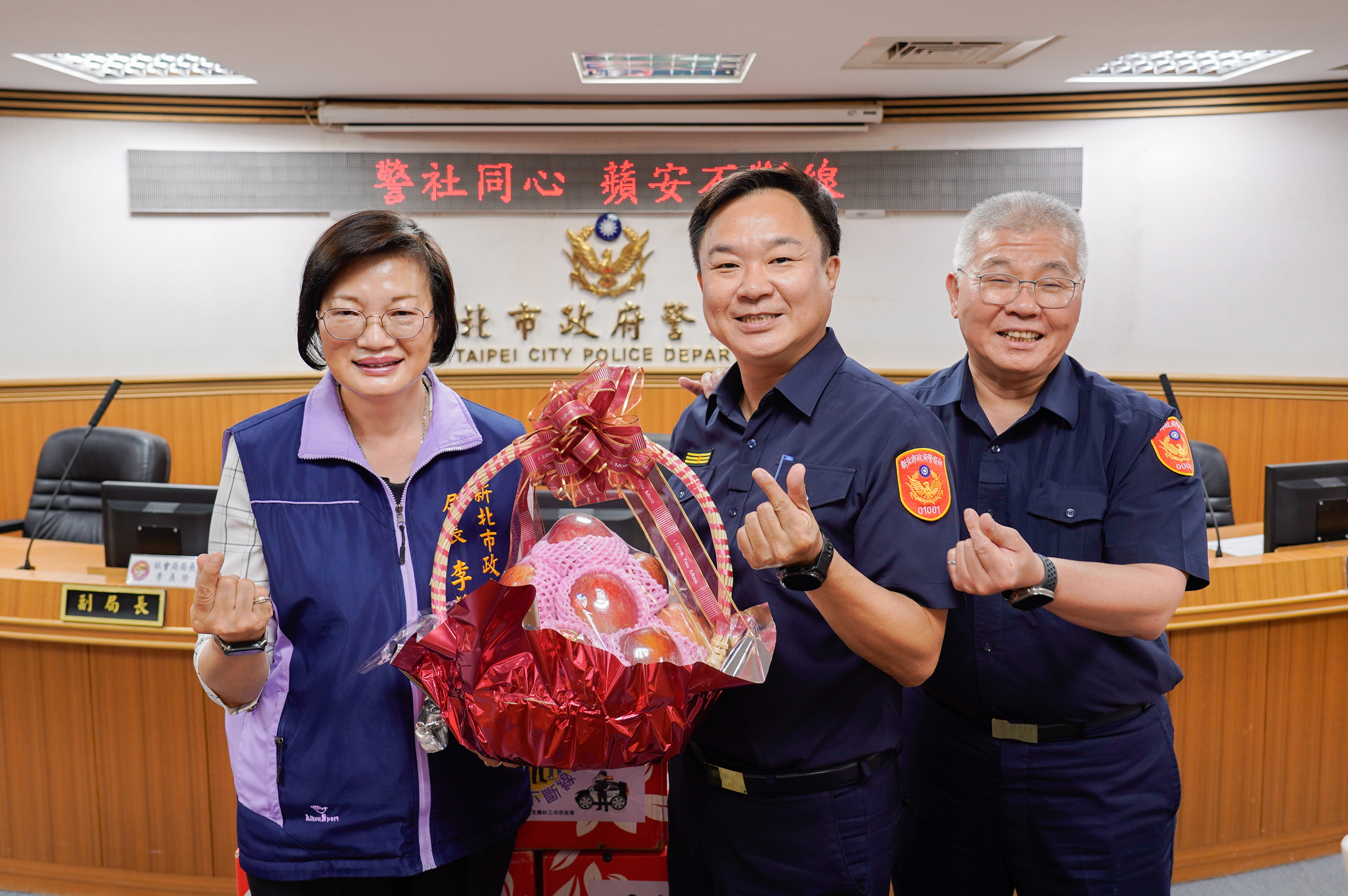 社會局長李美珍(左)致贈象徵「平安」的蘋果與感謝卡片，由警察局長方仰寧(右)、板橋分局長彭正中(中)代表受贈。