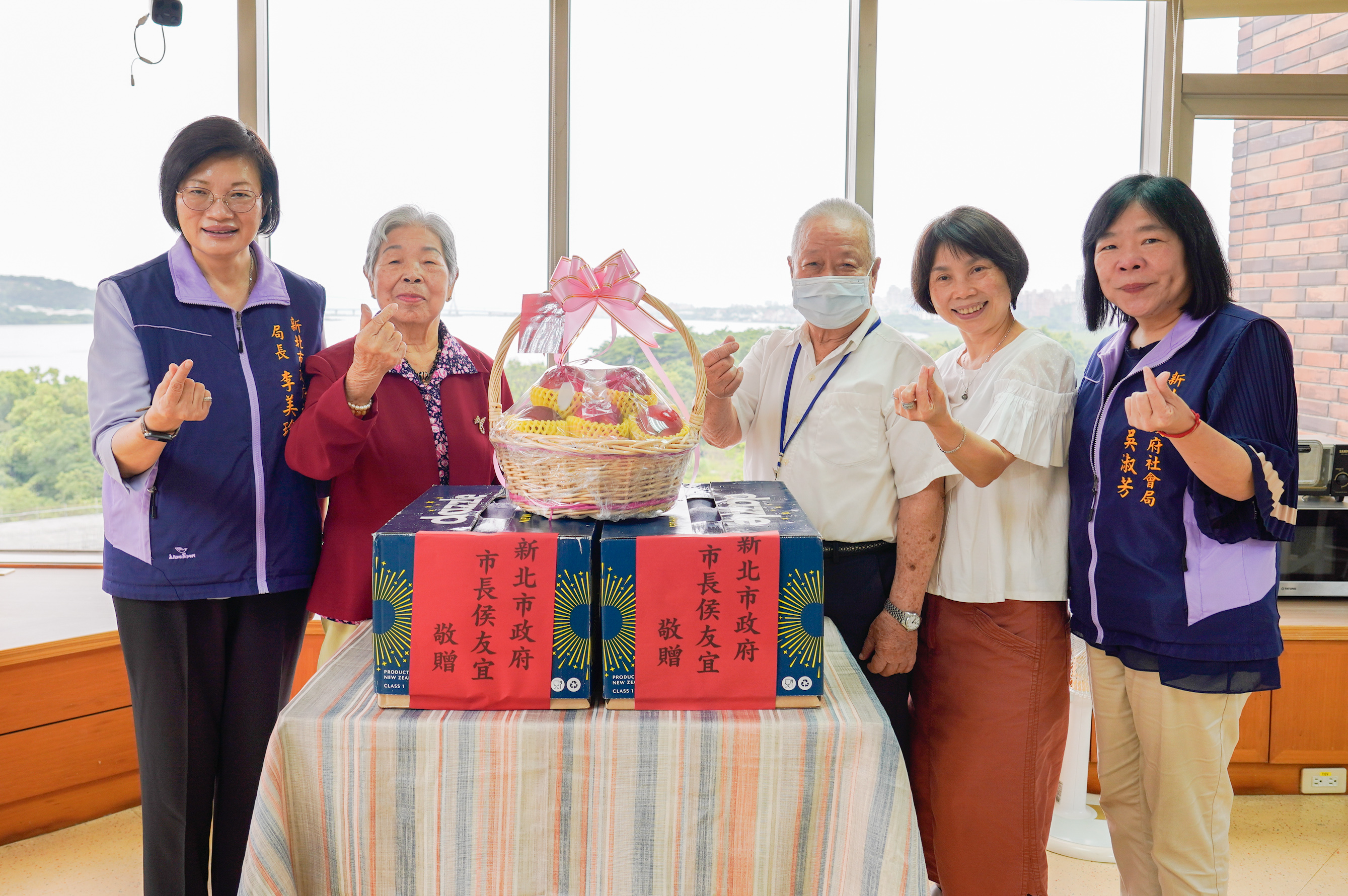 社會局長李美珍(左一)至仁濟安老所送上端午加菜金及蘋果，由住民賴文章(右三)及賴潘鳳英(左二)夫妻擔任代表受贈。