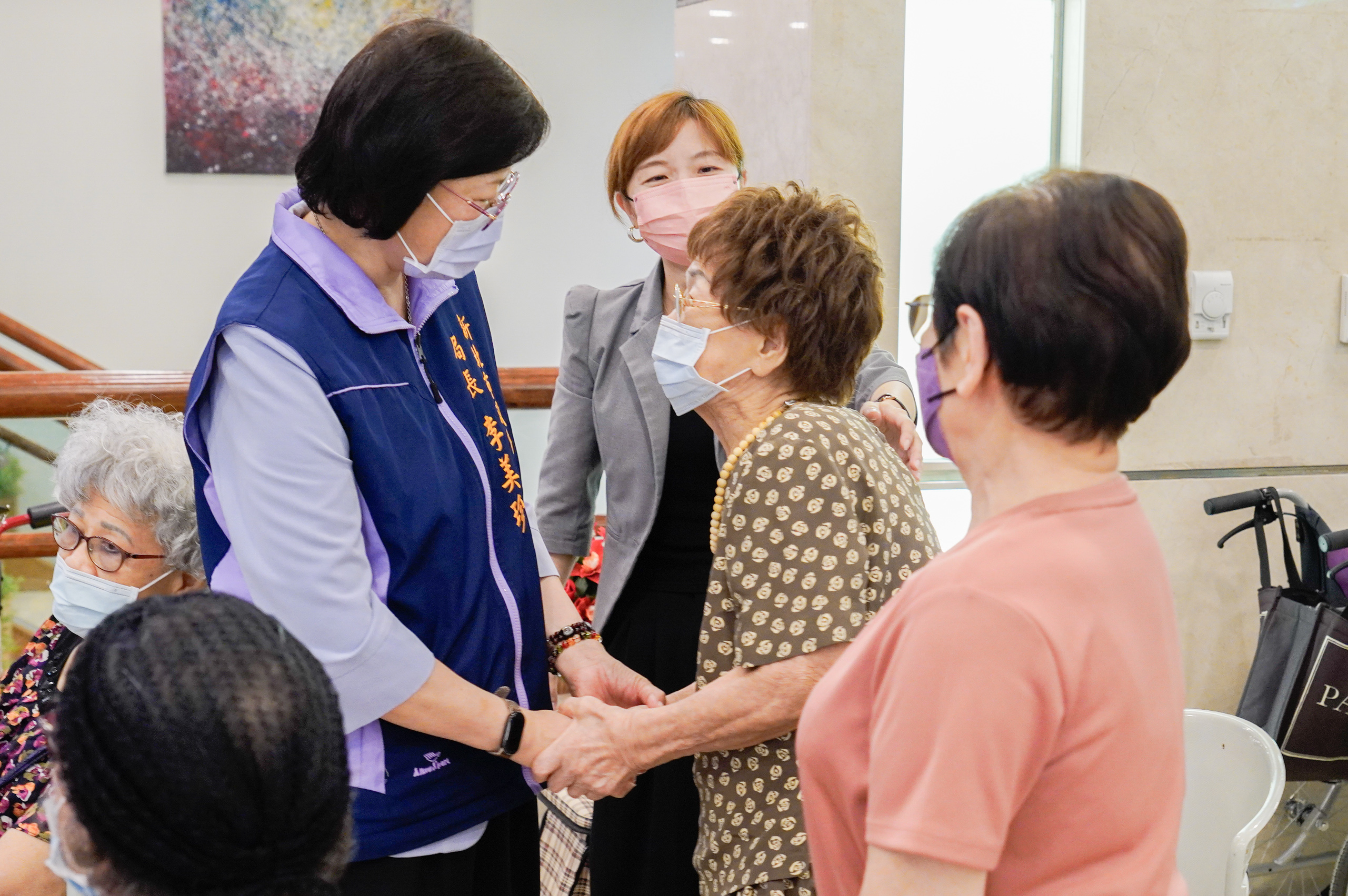 高齡89歲的雙連住民蔡惠玉(中)開心與社會局長李美珍分享機構生活。