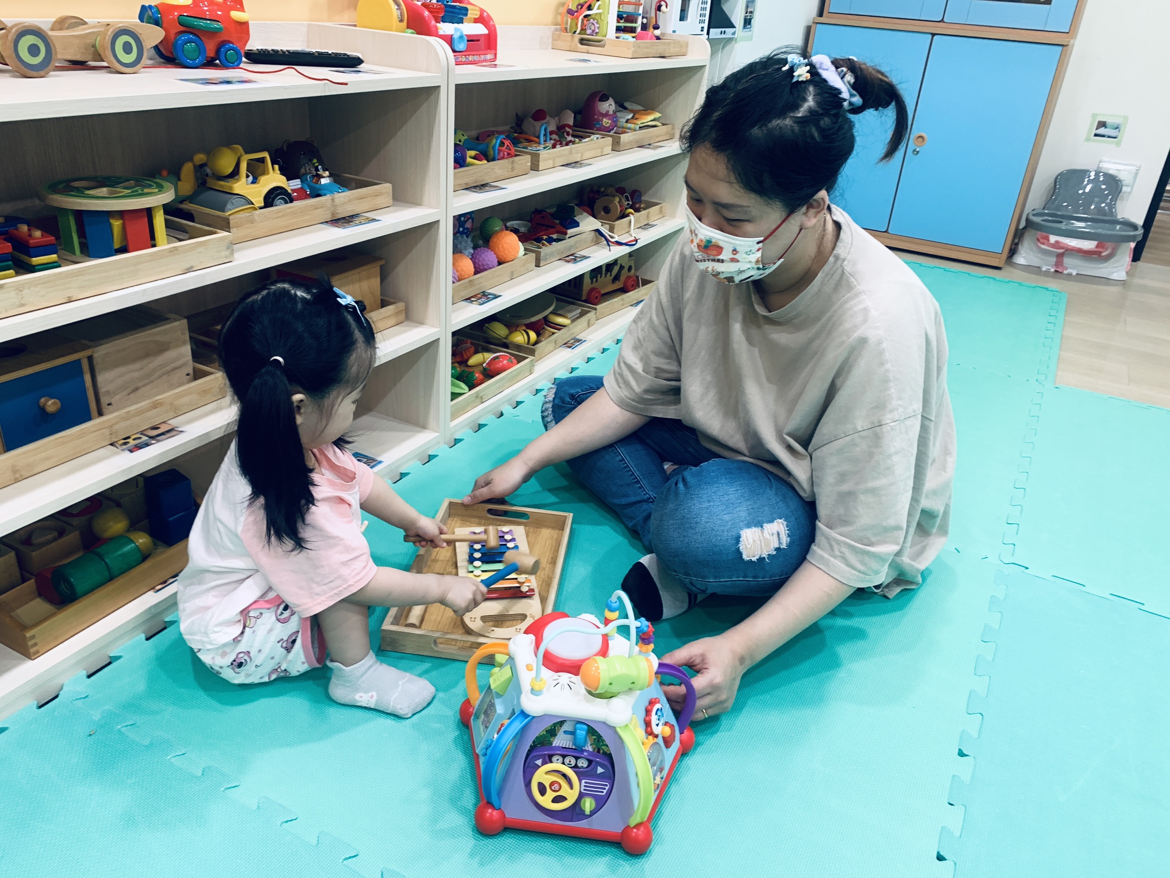  中和幸福種子社區定點臨托，托育人員陪伴幼兒敲打樂器