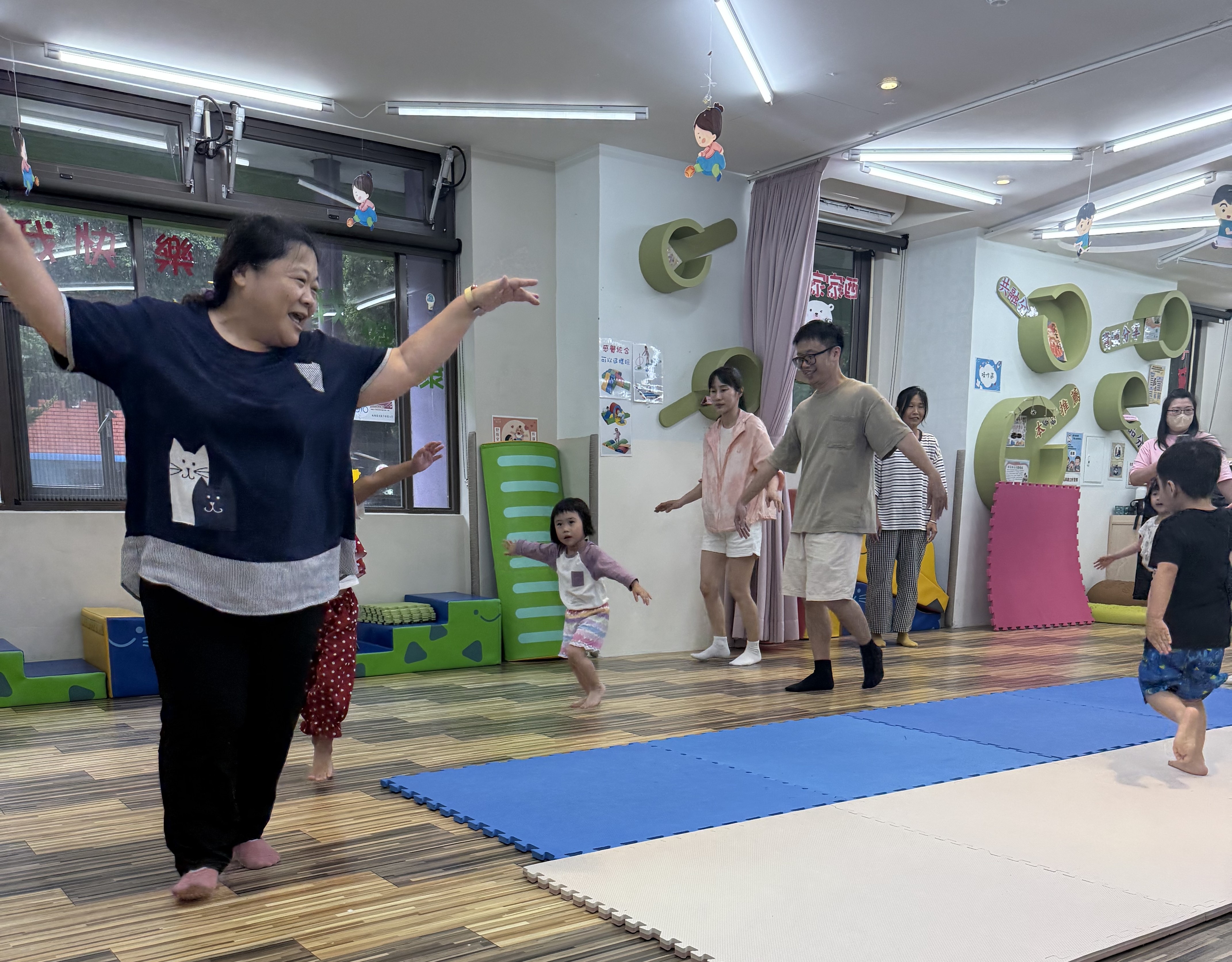  新北市第3區早資中心辦理親子感統團體遊戲，有豐富學前特殊教育經的輔導教師戈良惠（左1）帶領親子遊戲，想像自己像隻小鳥自在飛翔。