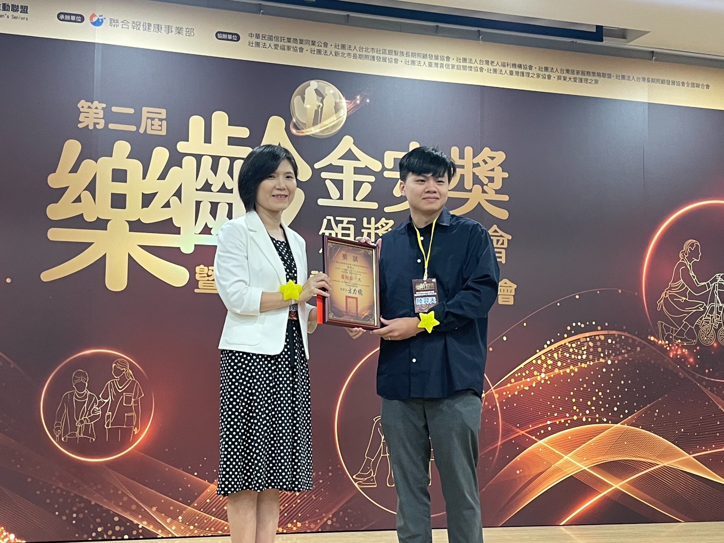 新北家防社工陸羿天服務案例獲老盟第二屆樂齡金安獎「暴虐防治護尊嚴組」第一名肯定，由衛福部保護司司長郭彩榕(左)授獎。
