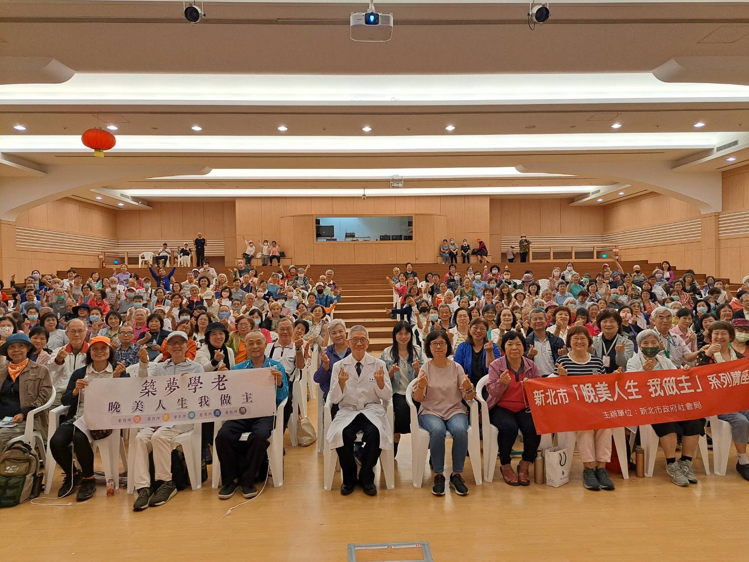  李嘉富醫師在雙和靜思堂以「越老越快樂─不失眠、不憂鬱的腦心保養術」為題進行專題演講，吸引近300位民眾聆聽。中為李嘉富醫師，中右為社會局副局長許秀能。