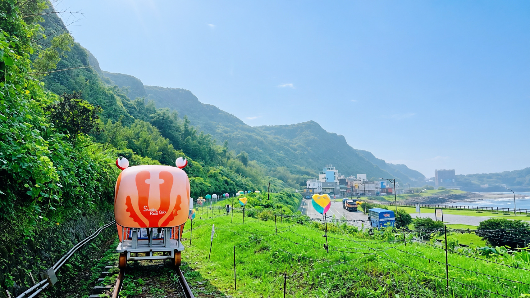 旅客搭乘深澳鐵道自行車特製的螃蟹造型車依山傍海前行，沿途不僅能飽覽新北北海岸的翠綠山巒，更能將開闊的海景盡收眼底。