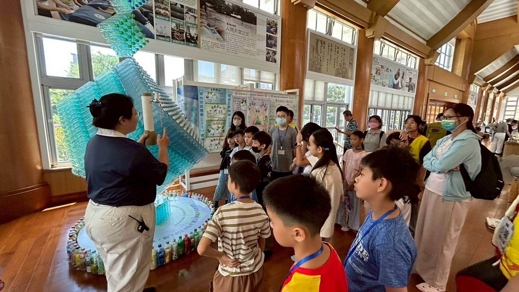  小志工參訪環境教育展示空間，慈濟師姐透過回收再利用藝術裝置，教導認識資源循環及水資源。