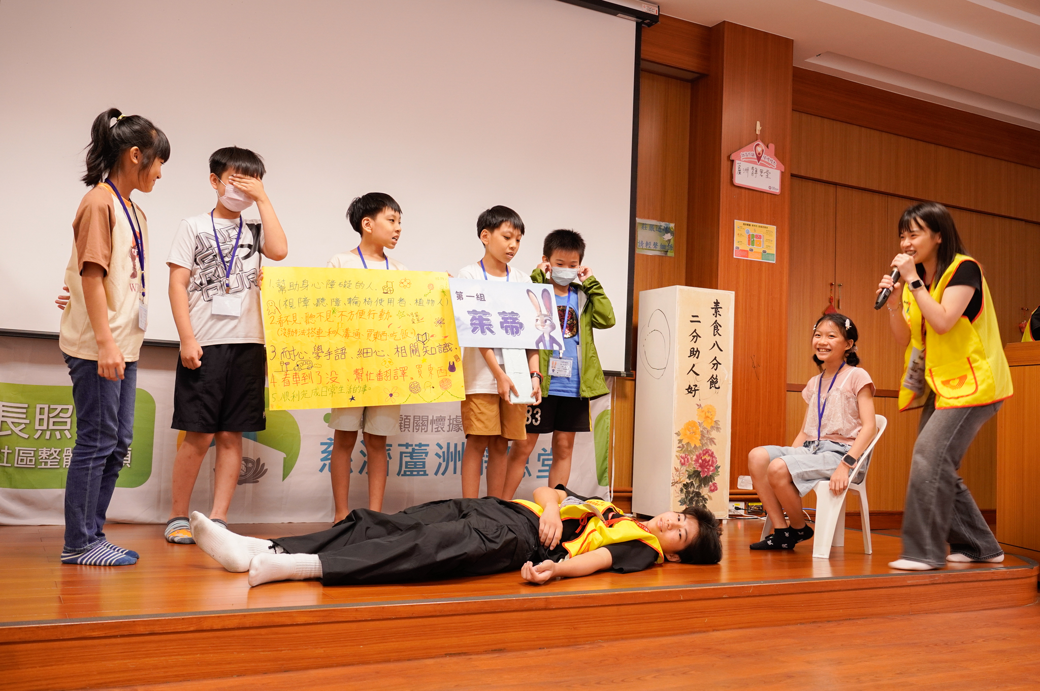  小朋友在志願服務推廣中心志工的帶領下，以行動劇表現如何幫助身障朋友。