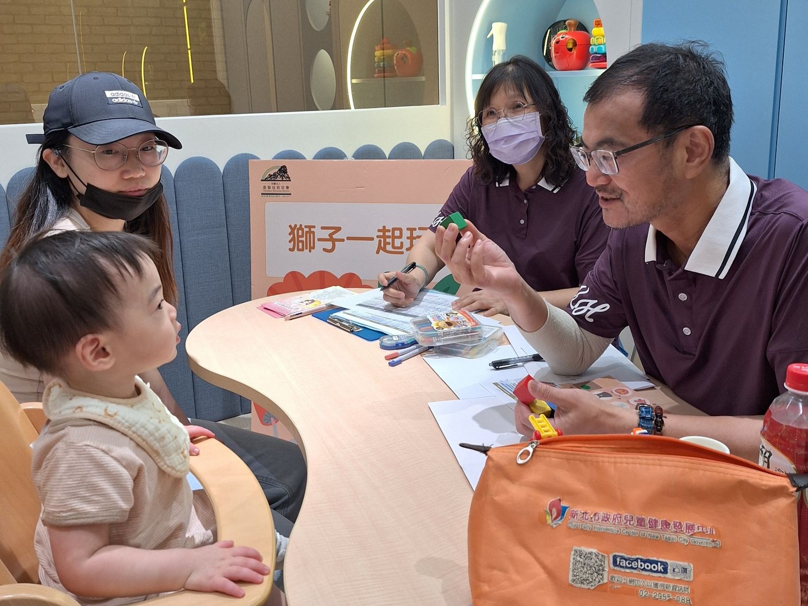  三峽恩主公醫院林宏琪（右）醫師利用育兒寶貝袋的玩具與幼兒互動，並觀察幼兒的發展。