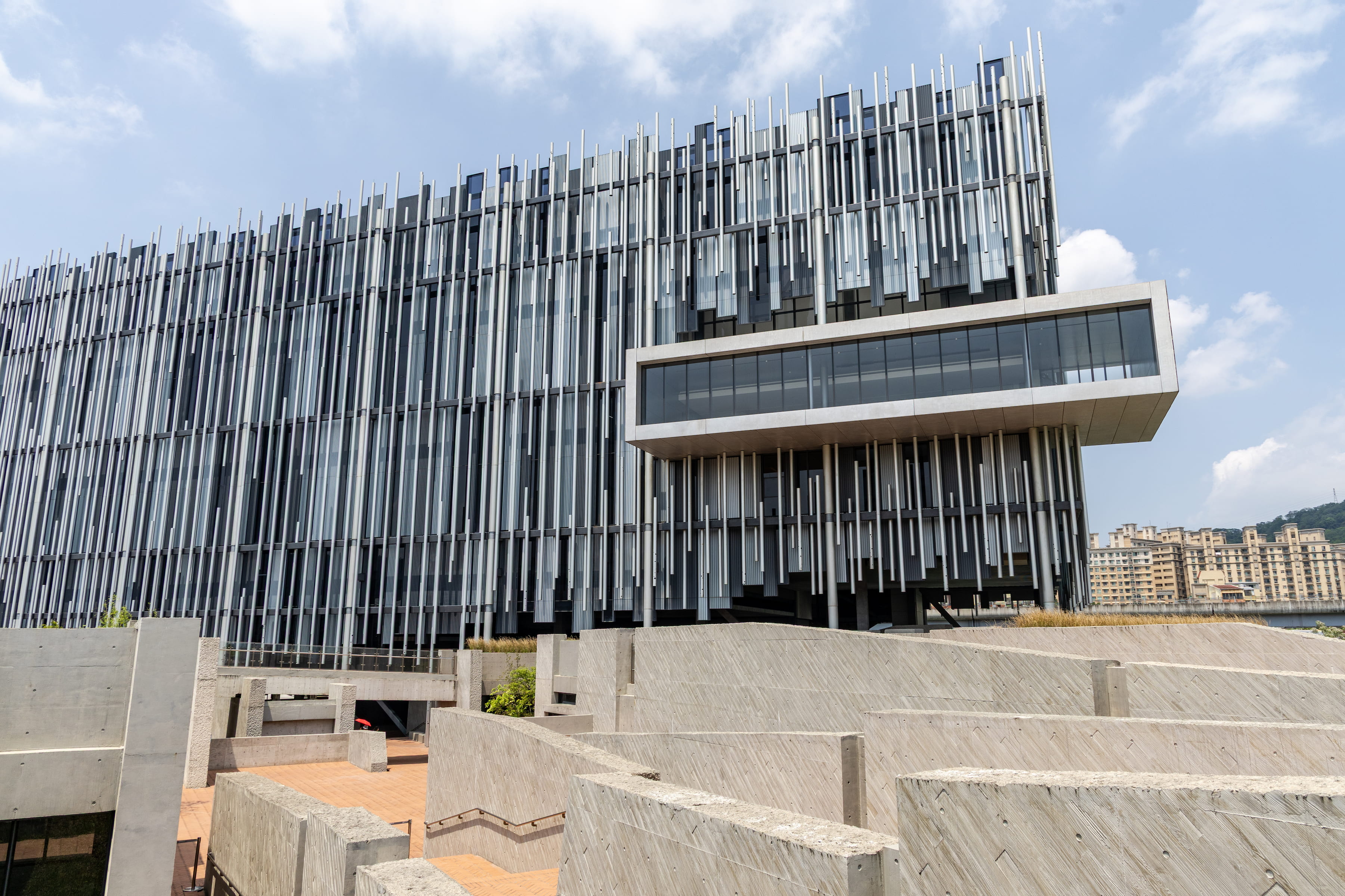 坐落於大漢溪畔的新北市美術館，以蘆葦為設計概念，錯落有致的垂直線條， 完美展現自然與現代建築的共融之美。