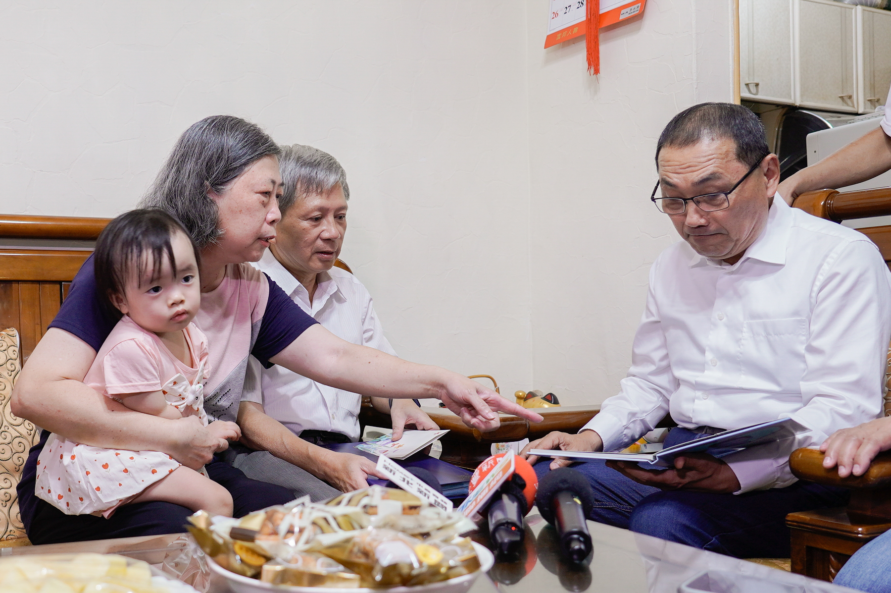 寄養媽媽劉仙珍向侯友宜市長分享小立的照片，提起當年照顧點滴，昔日相處時光彷彿歷歷在目。