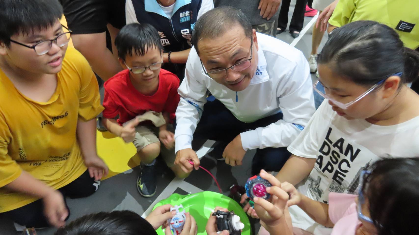 侯市長視察樹林三龍天幕球場，和現場孩子們打戰鬥陀螺，開心合影。