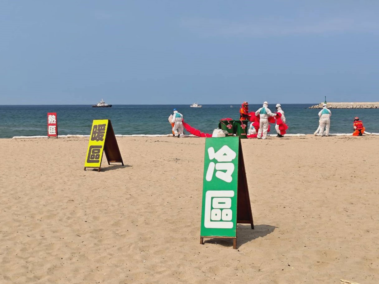 環保局和岸巡同仁進行岸際油污清除