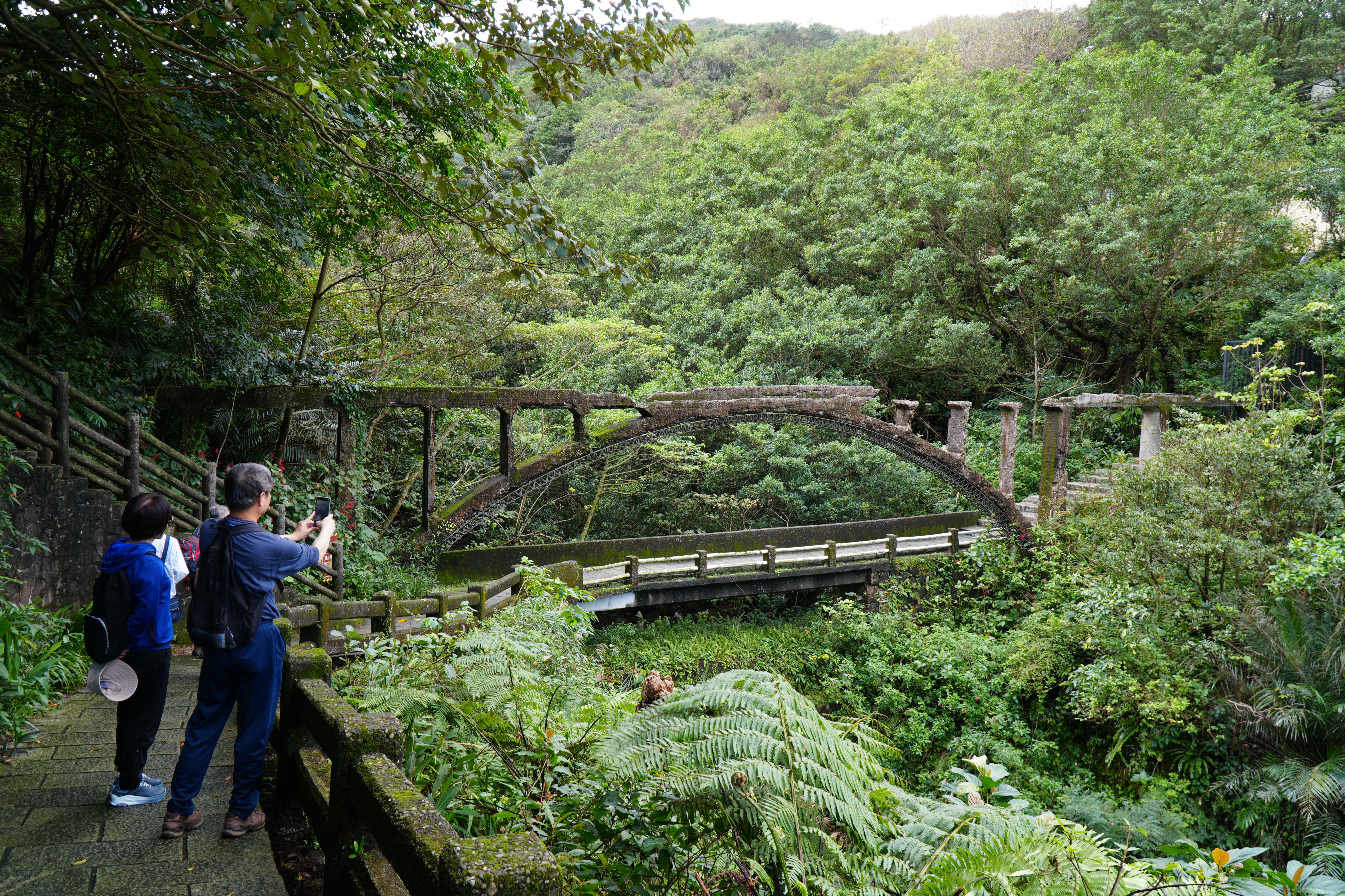 藏身於蓊鬱山林間的「三層橋」，由清代石拱、日治水圳與現代水泥橋交疊而成，跨越三個時代的百年歲月