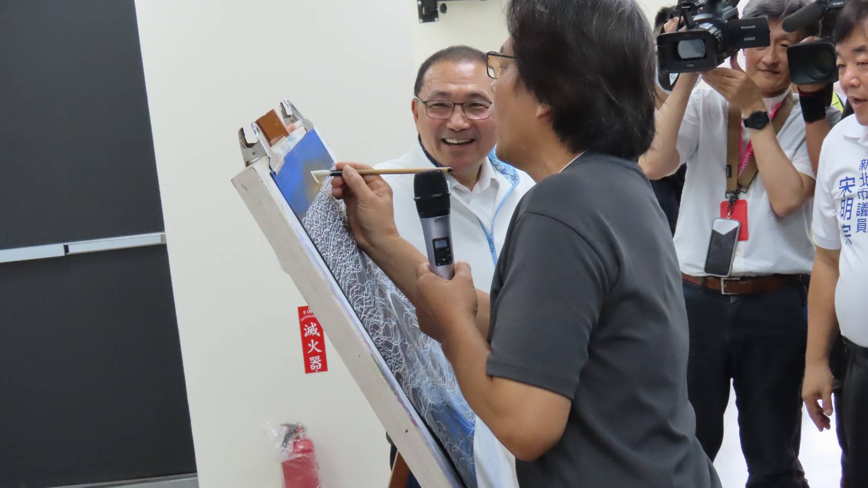 侯市長友宜前往活動中心內的繪畫課程，與學員們互動熱絡合影，留下日出畫作。
