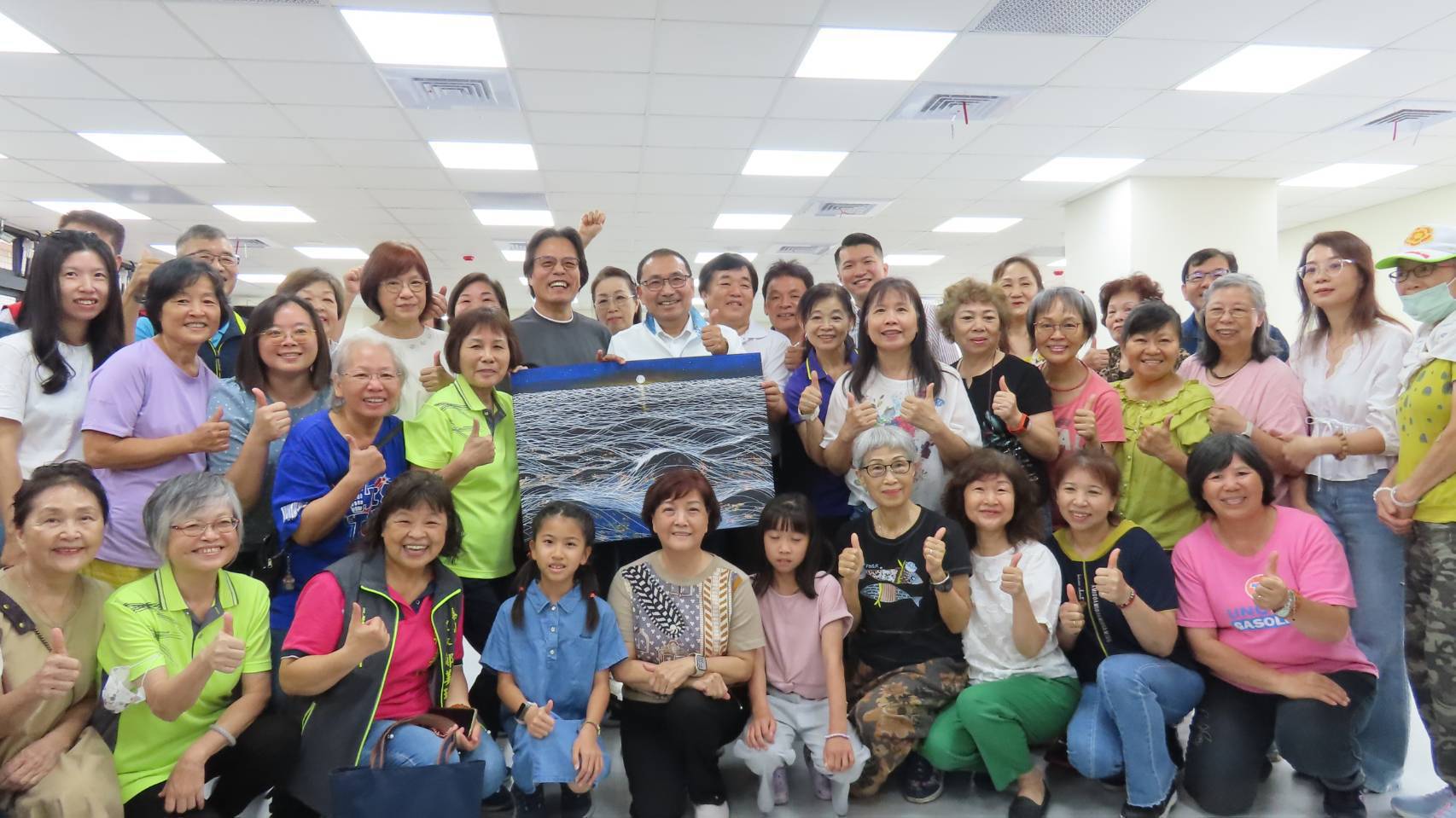 侯友宜市長前往活動中心內的繪畫課程，與學員們互動熱絡合影，留下日出畫作。