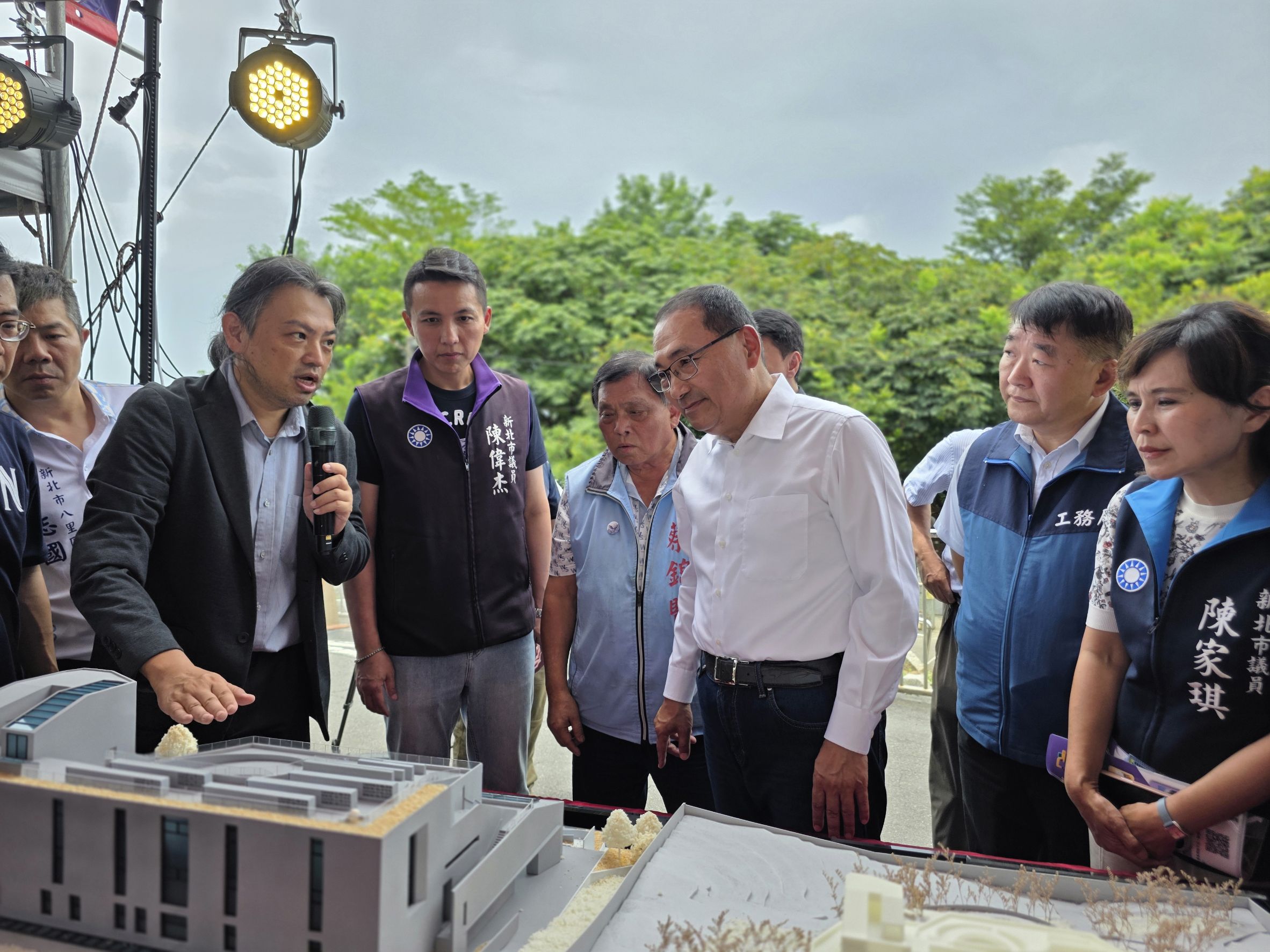 侯友宜市長(穿白襯衫者)觀看八里第二納骨塔的建物模型，建築師從旁解說。