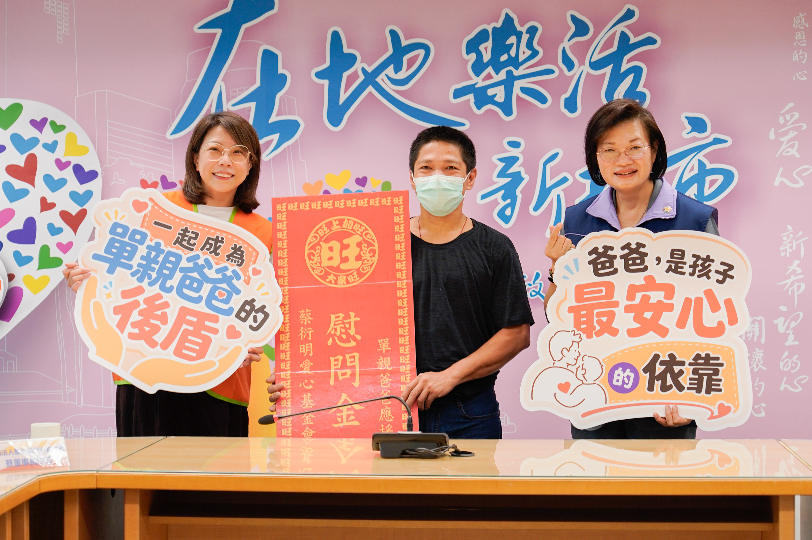 蔡衍明愛心基金會攜手新北市社會局，提供80戶弱勢單親爸爸家庭，每戶5000元的慰問金。圖左起為基金會董事長蔡紹云、受贈代表吳爸爸、社會局長李美珍。