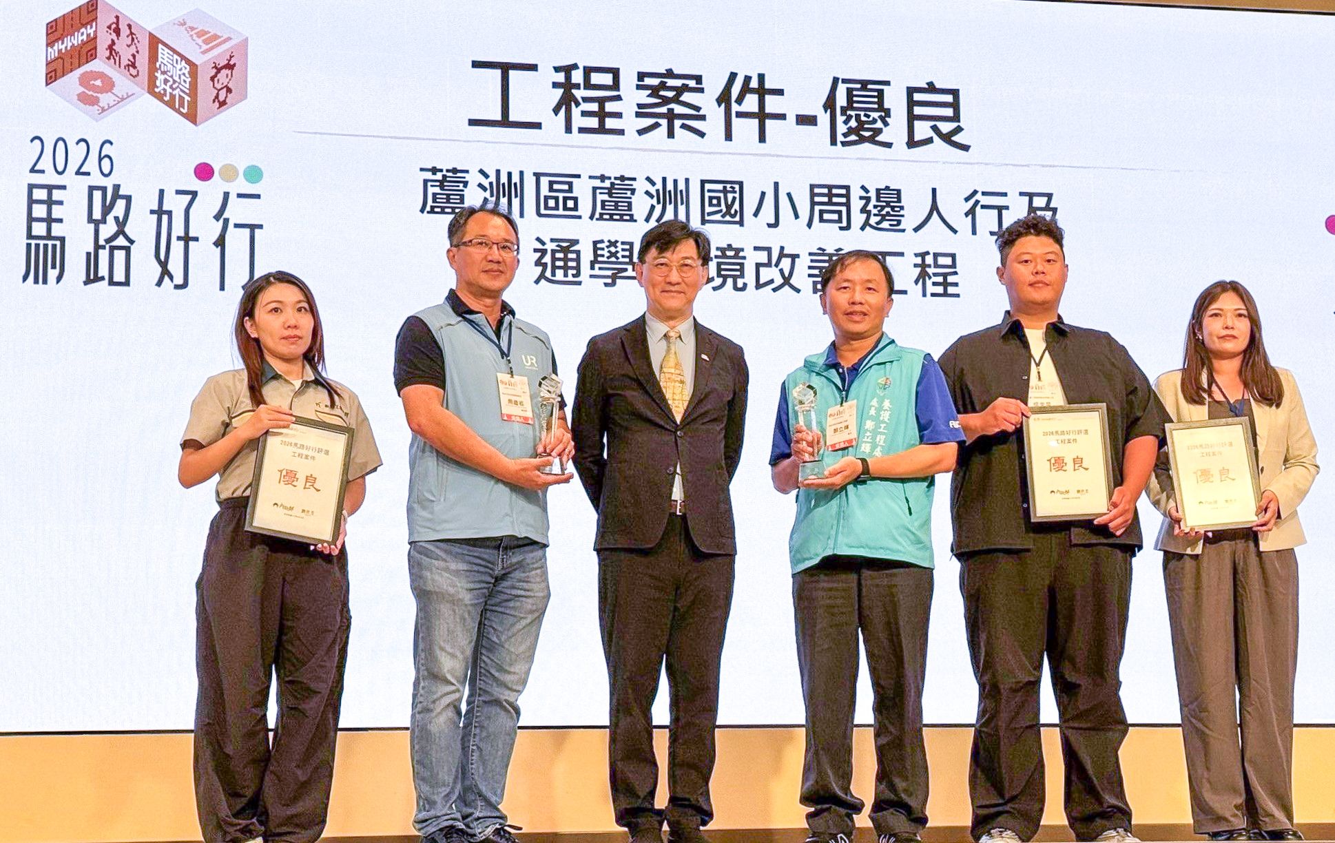 蘆洲國小周邊人行及通學環境改善工程，在2026馬路好行評選獲得優良，養工處長鄭立輝(左四)出席典禮接受頒獎。
