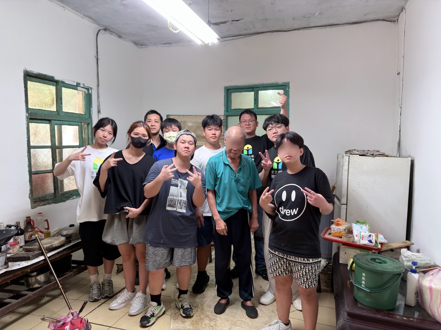 新北市少年培力園少年工班在為獨居長輩粉刷牆壁、安裝照明設備後開心地合影。