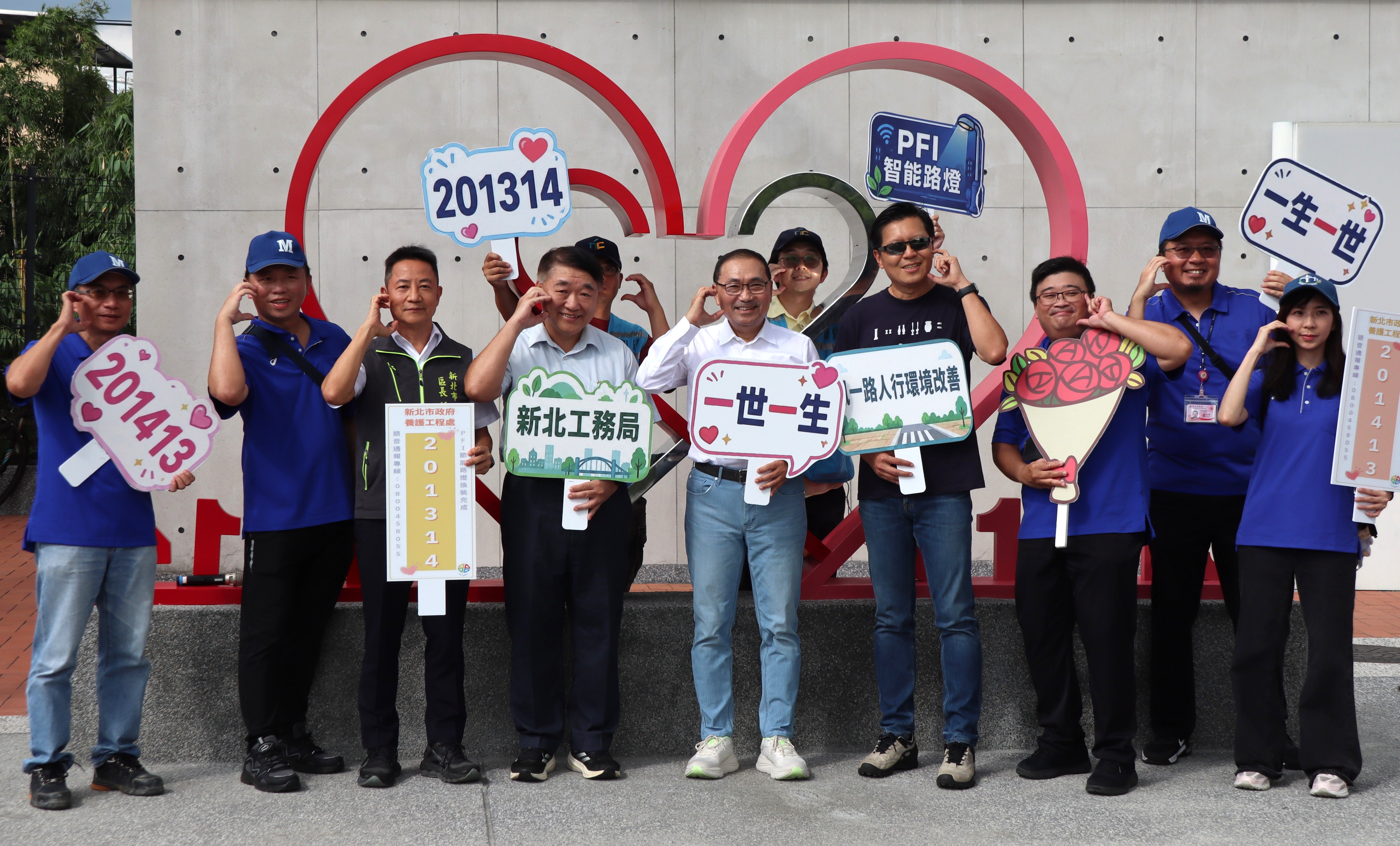 侯友宜市長(中)與朱惕之副市長(左四)、工務局團隊在「201314」愛心造型街道家具合影，展現公共設施融入浪漫的創意巧思。
