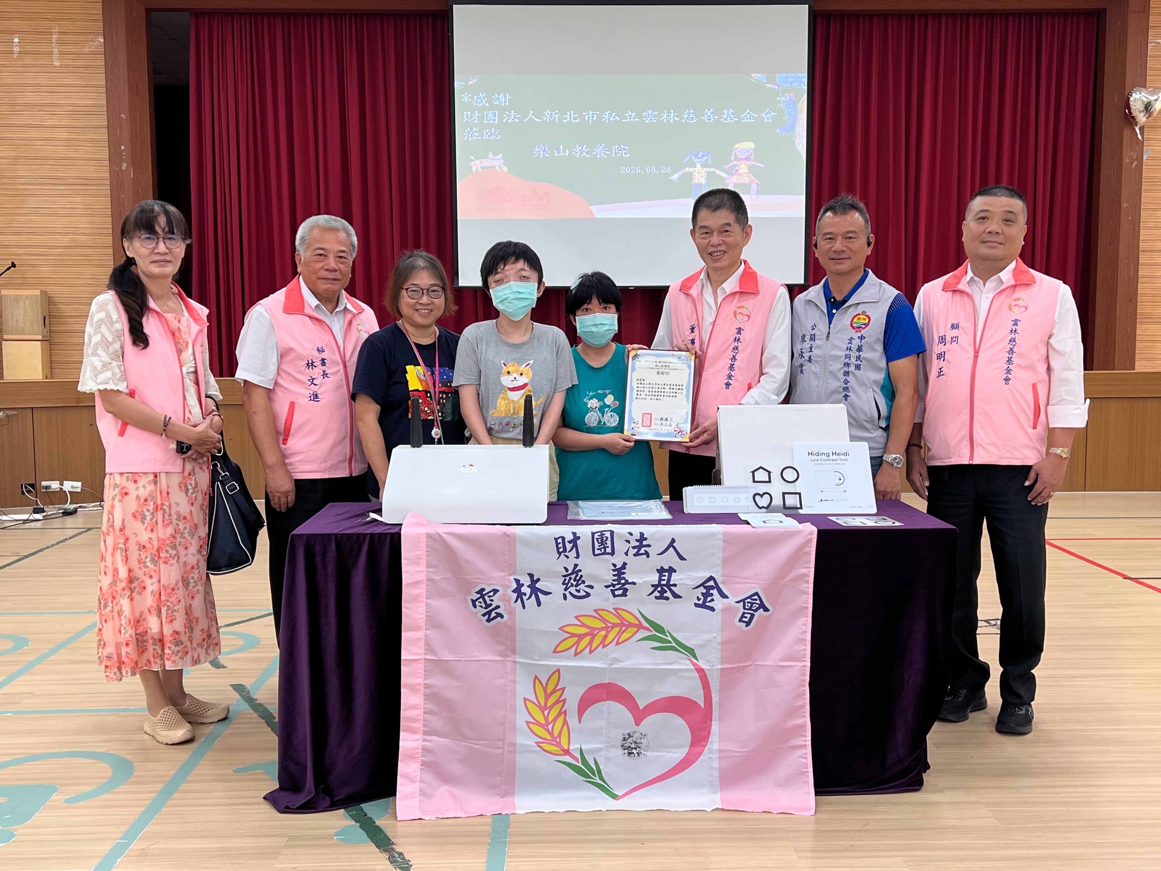  樂山教養院院生回贈感謝狀給財團法人雲林慈善基金會董事長林進忠，左3為吳淑惠院長。