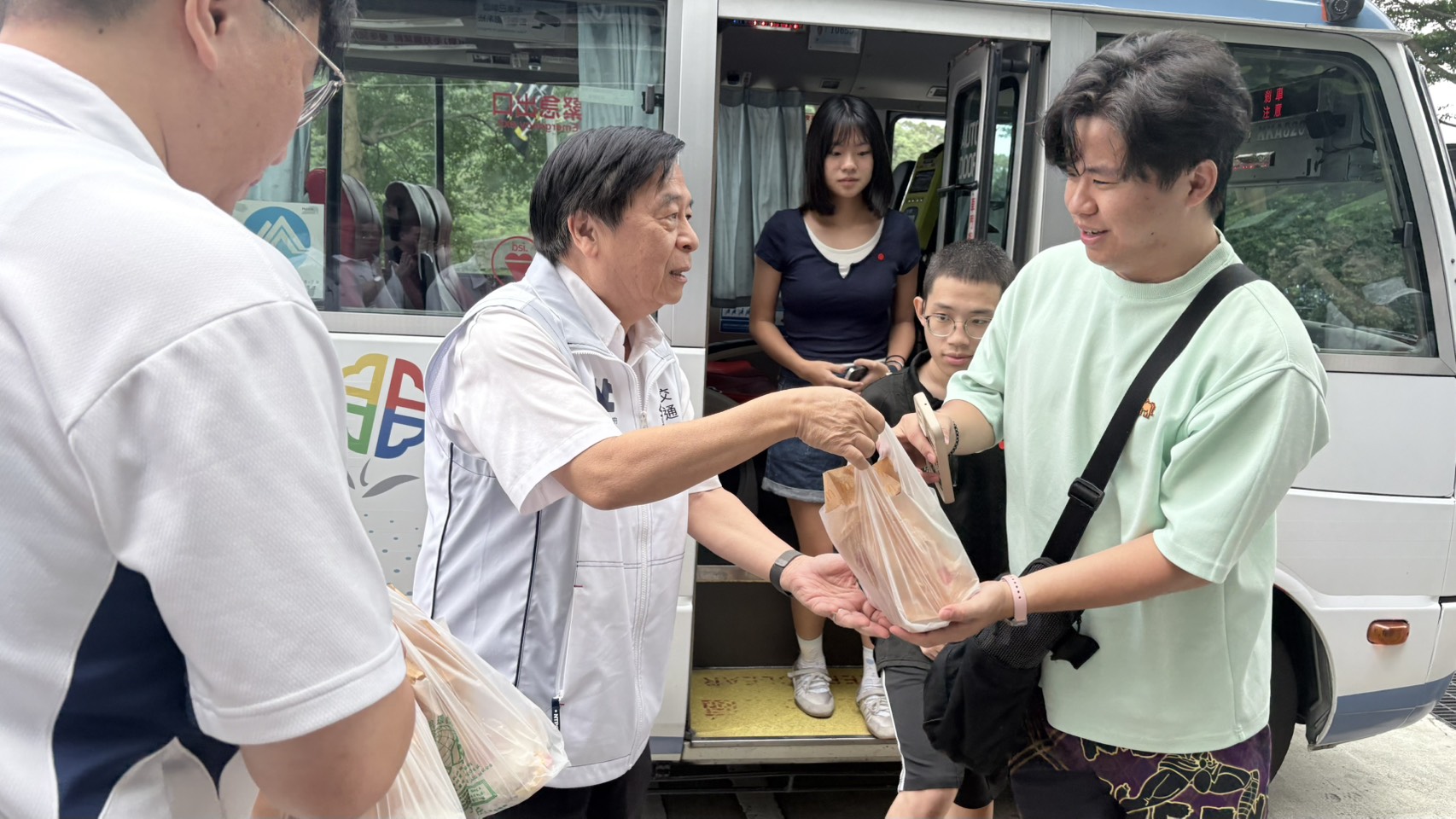 交通局長鍾鳴時為搭乘首班跳蛙公車的學生送上早餐