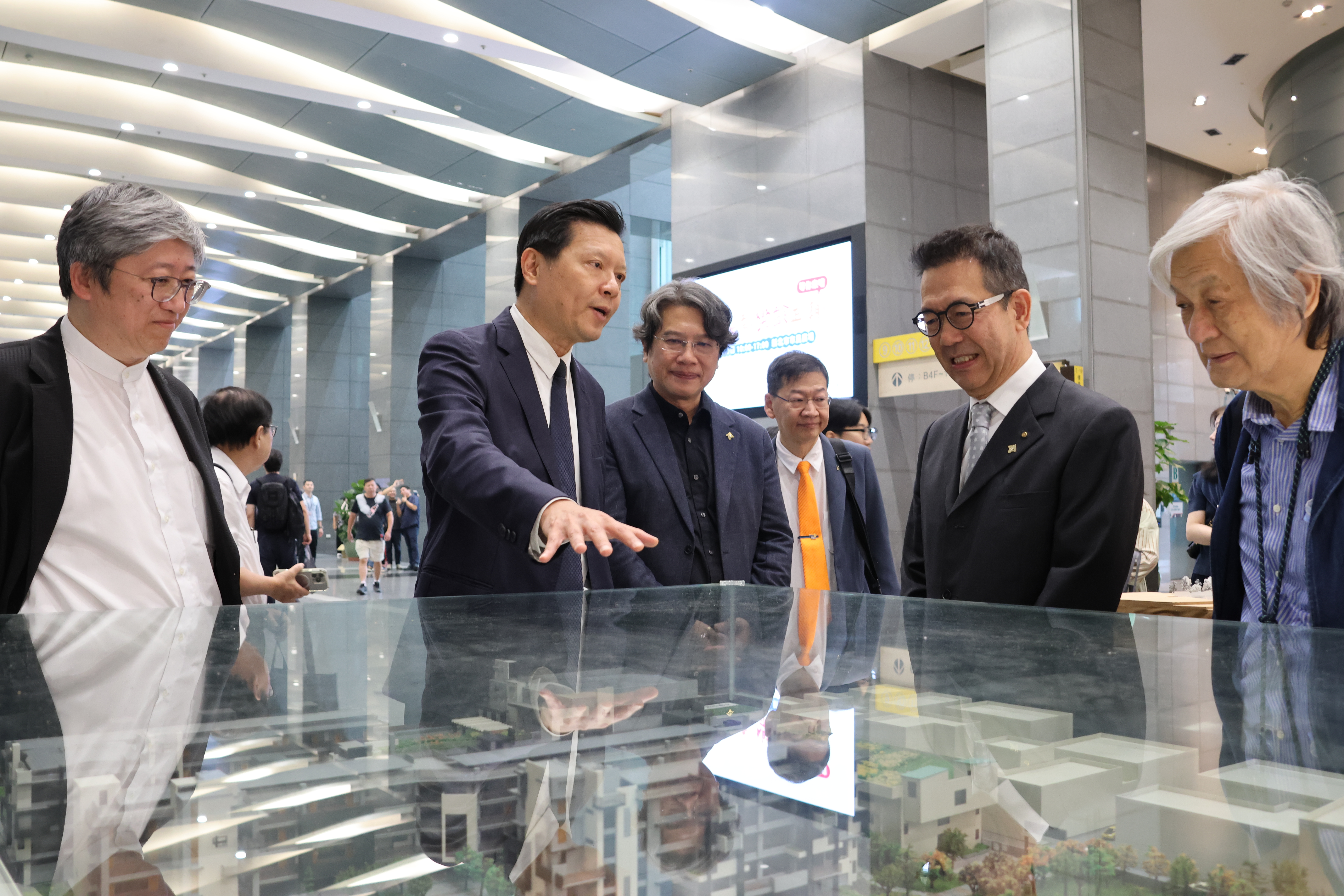 朱惕之副市長(左二)參觀新北市優良建築師暨傑出作品獎成果展，與傑出建築師們一起觀看模型。