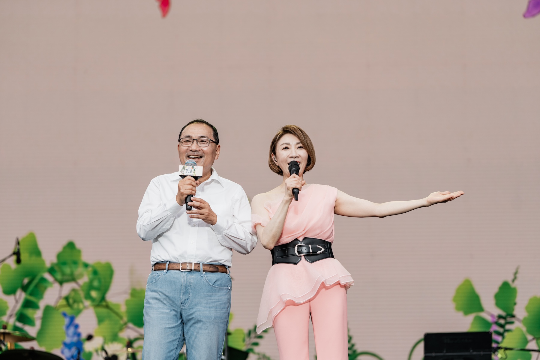 新北市長侯友宜（左）今（12）日出席「2026新北市綠生活音樂節」，與歌手李翊君（右）在舞台上合唱經典歌曲〈萍聚〉，與現場民眾一同重溫熟悉旋律。