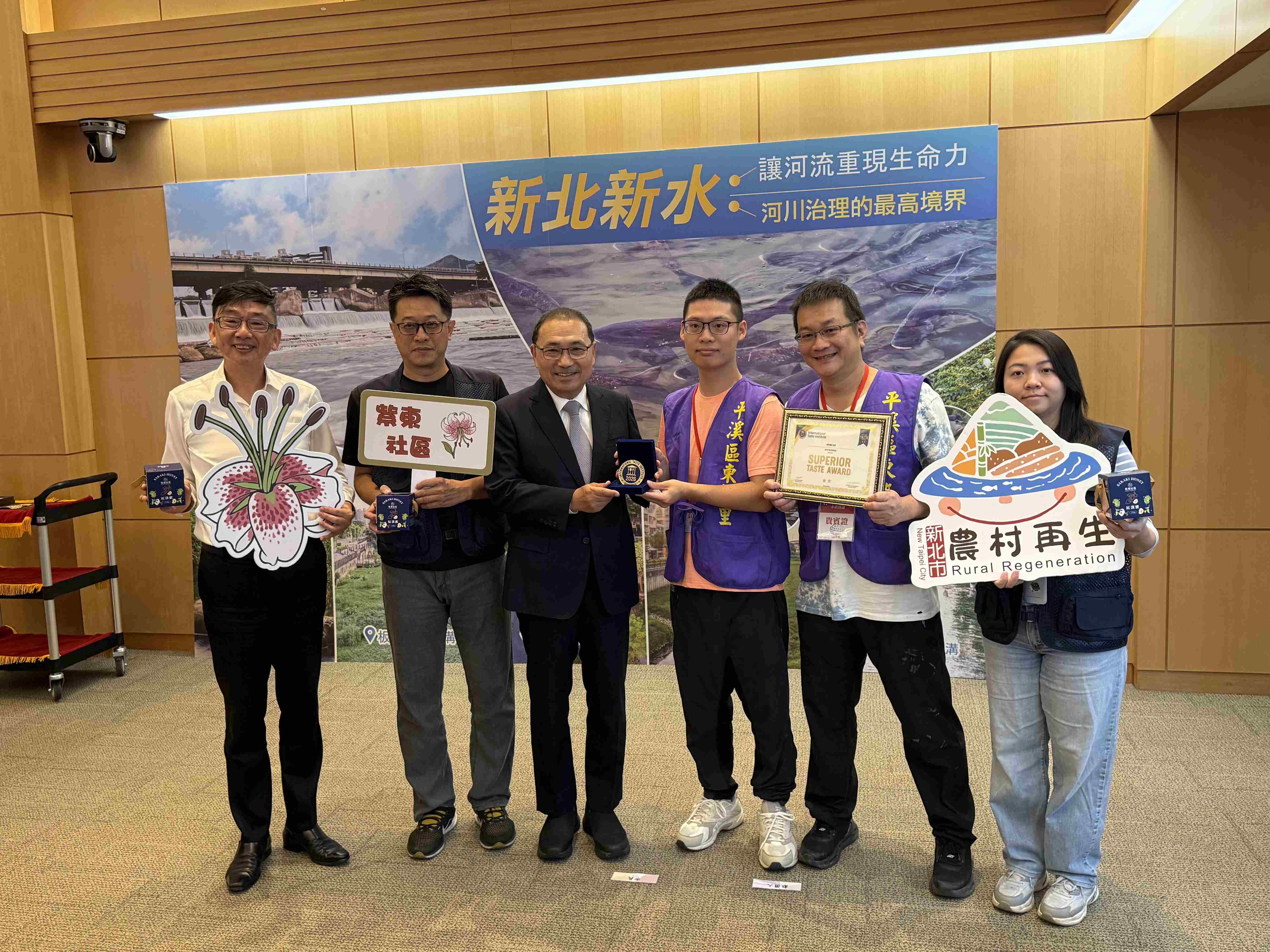 平溪紫東社區「紅淡蜜」榮獲國際風味評鑑所2026年「風味絕佳獎章」二星獎章，社區發展協會理事長潘俊青(右2)及蜂農陳韋齊(右3)代表於市政會議獻獎