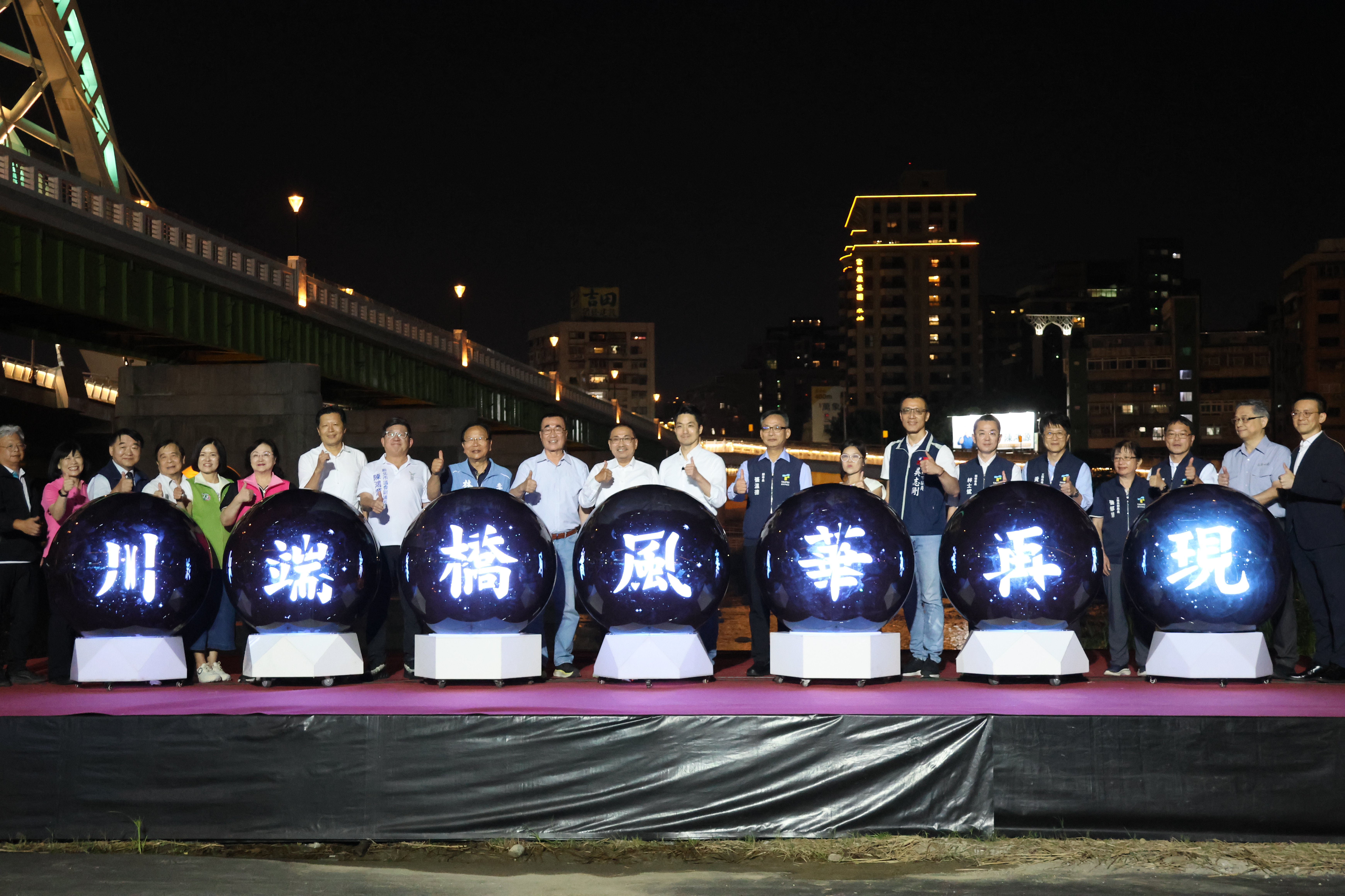 雙北市政府團隊、民意代表共同出席川端橋啟用儀式，眾人站在「川端橋風華再現」燈光裝置球體前方合影留念。