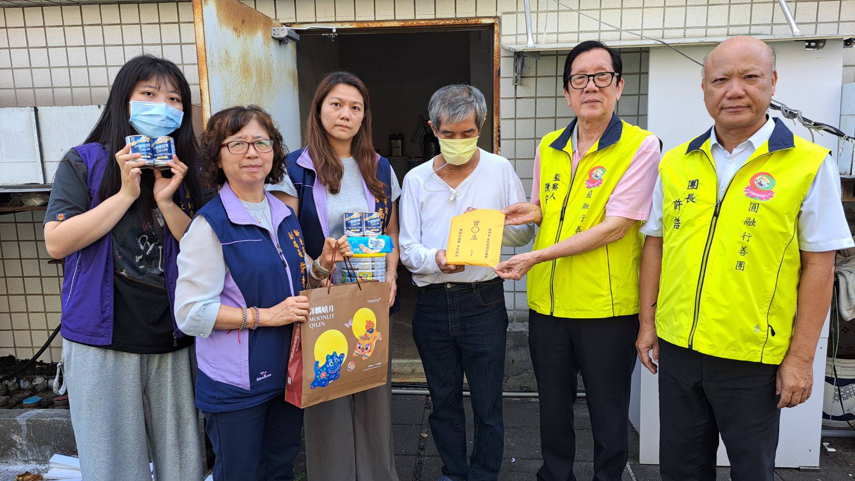 社會局副局長許秀能（左2）、圓融行善團長許誥（右1）、監察人陳安正（右2）等人，將善款交付予曾男及社福中心，按月提撥1萬元幫助度過難關。左1為社工吳雨函。左3為新莊社福中心主任高涓娟。