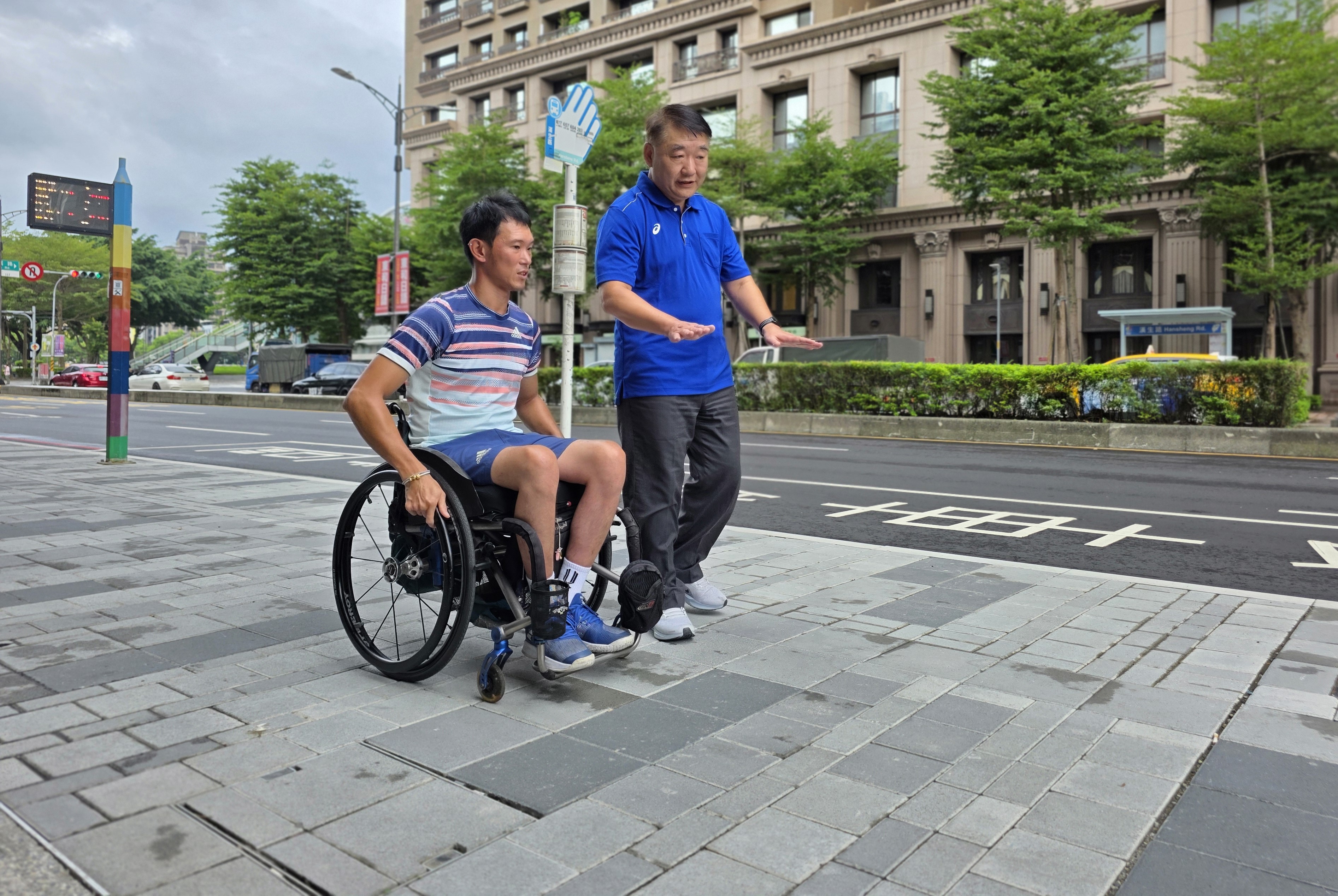 工務局長馮兆麟(右)與輪椅網球選手唐兆漢(左)實地走訪改善後的漢生東路人行道，拓寬的人行道阻礙減少，通行更安心。