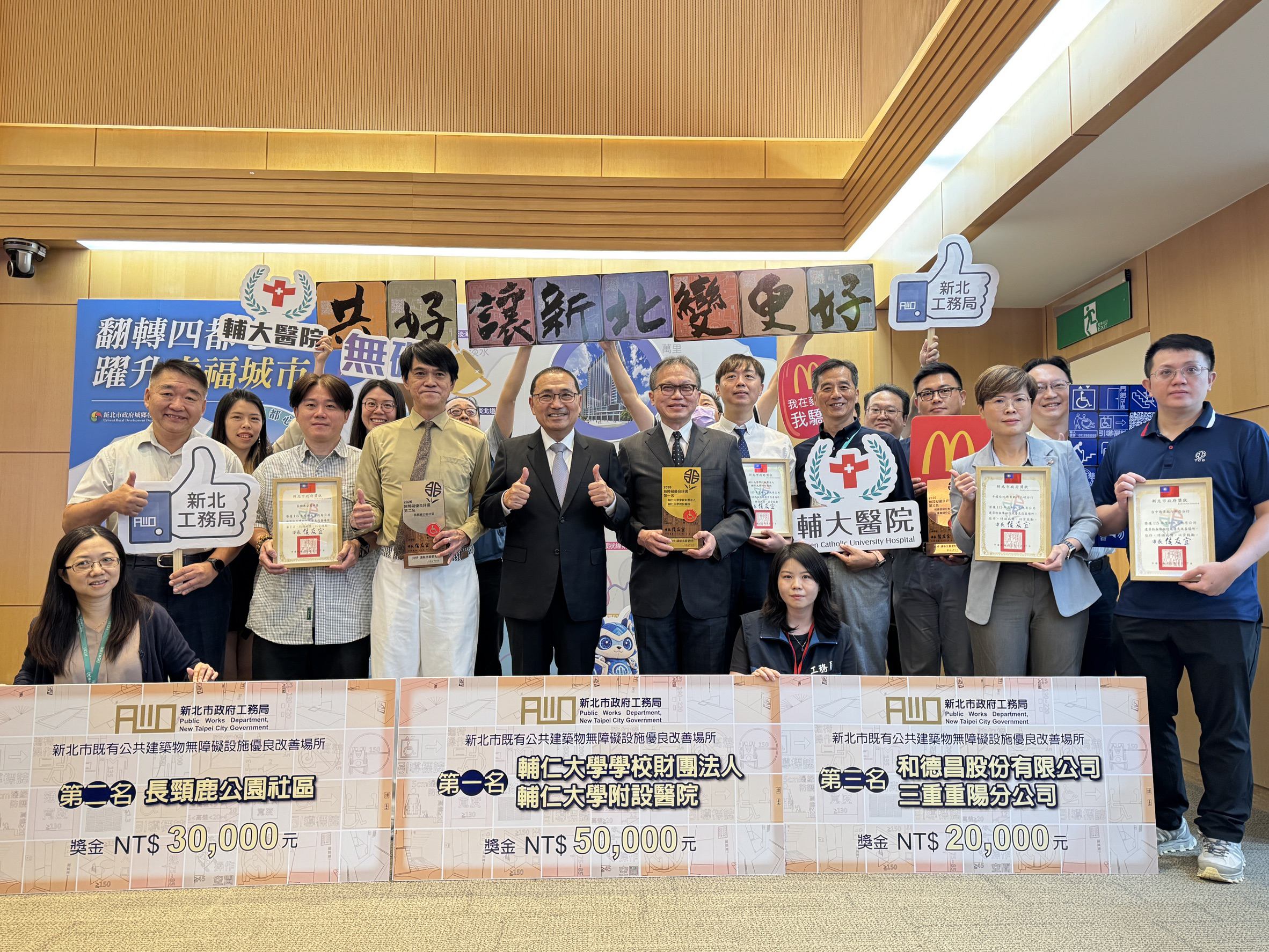侯友宜市長(中)頒獎表揚115年度無障礙設施優良場所獲獎單位，並與獲獎醫院、社區及企業的代表合影，肯定其積極改善無障礙環境。