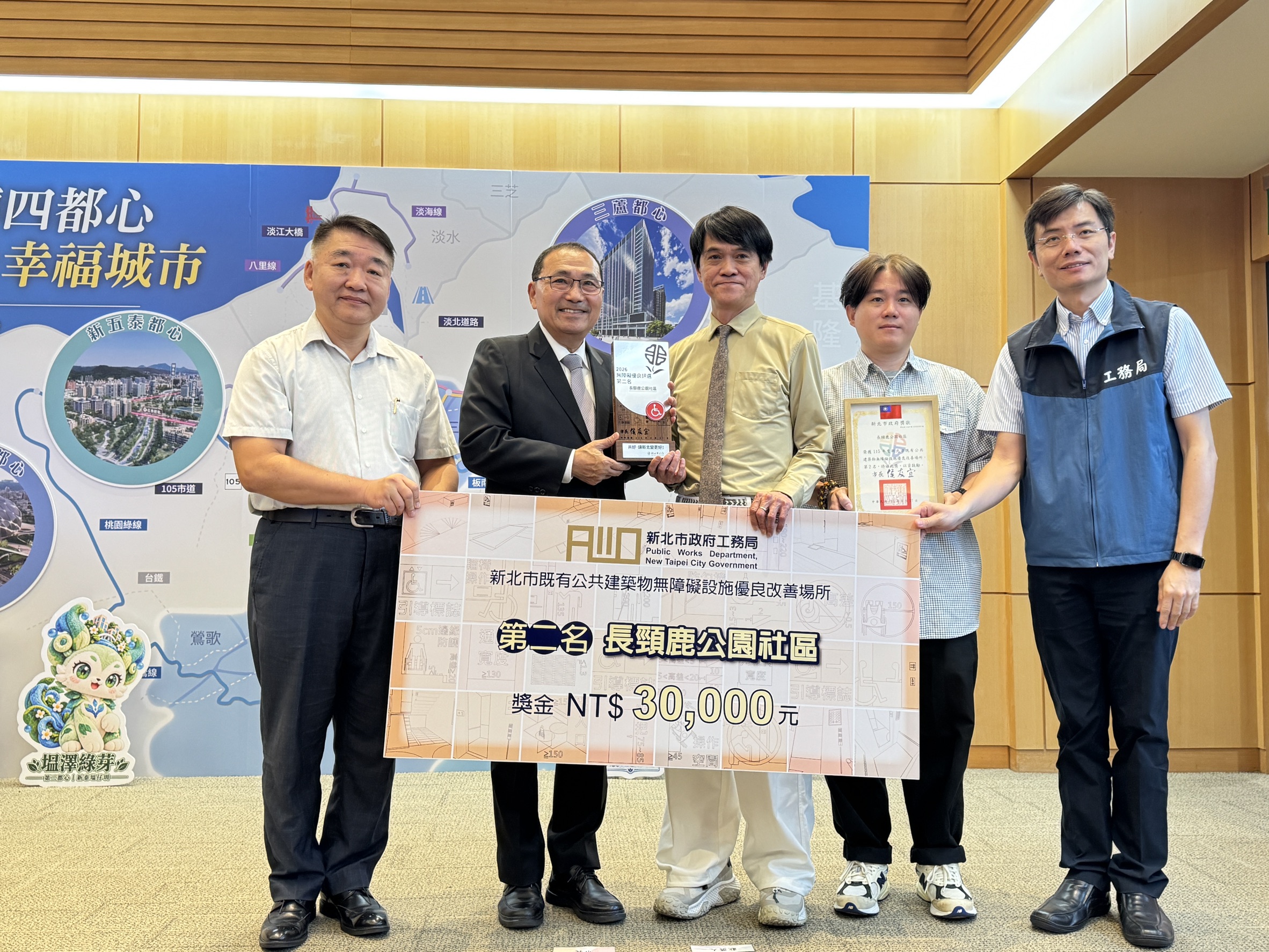 長頸鹿公園社區獲評為115年度新北市公共建築物無障礙優良場所優等第二名，侯友宜市長(左二)於市政會議中親自頒獎表揚。