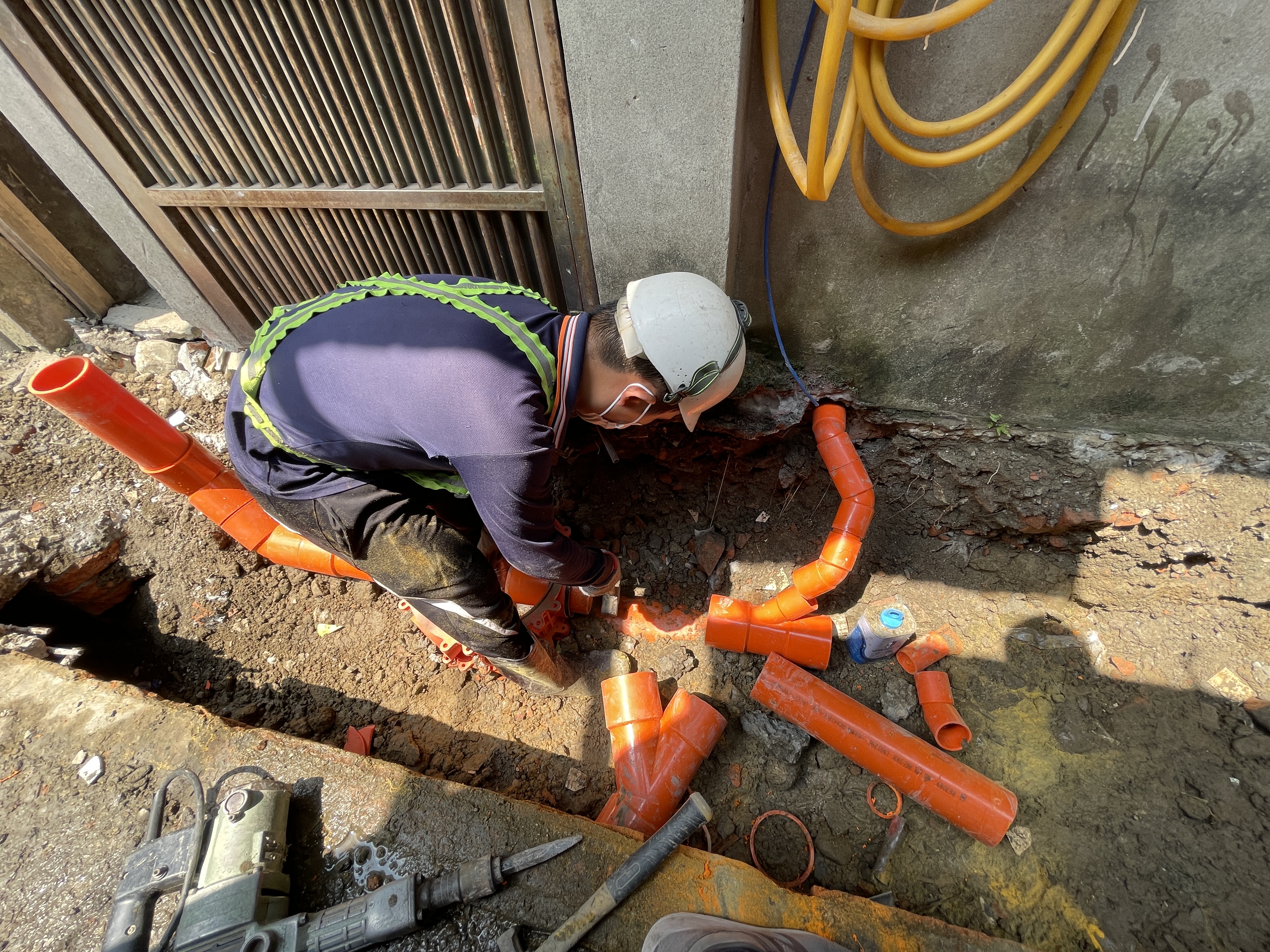 施工人員將住家的污水管接入污水下水道系統，污水不再排入水溝造成惡臭
