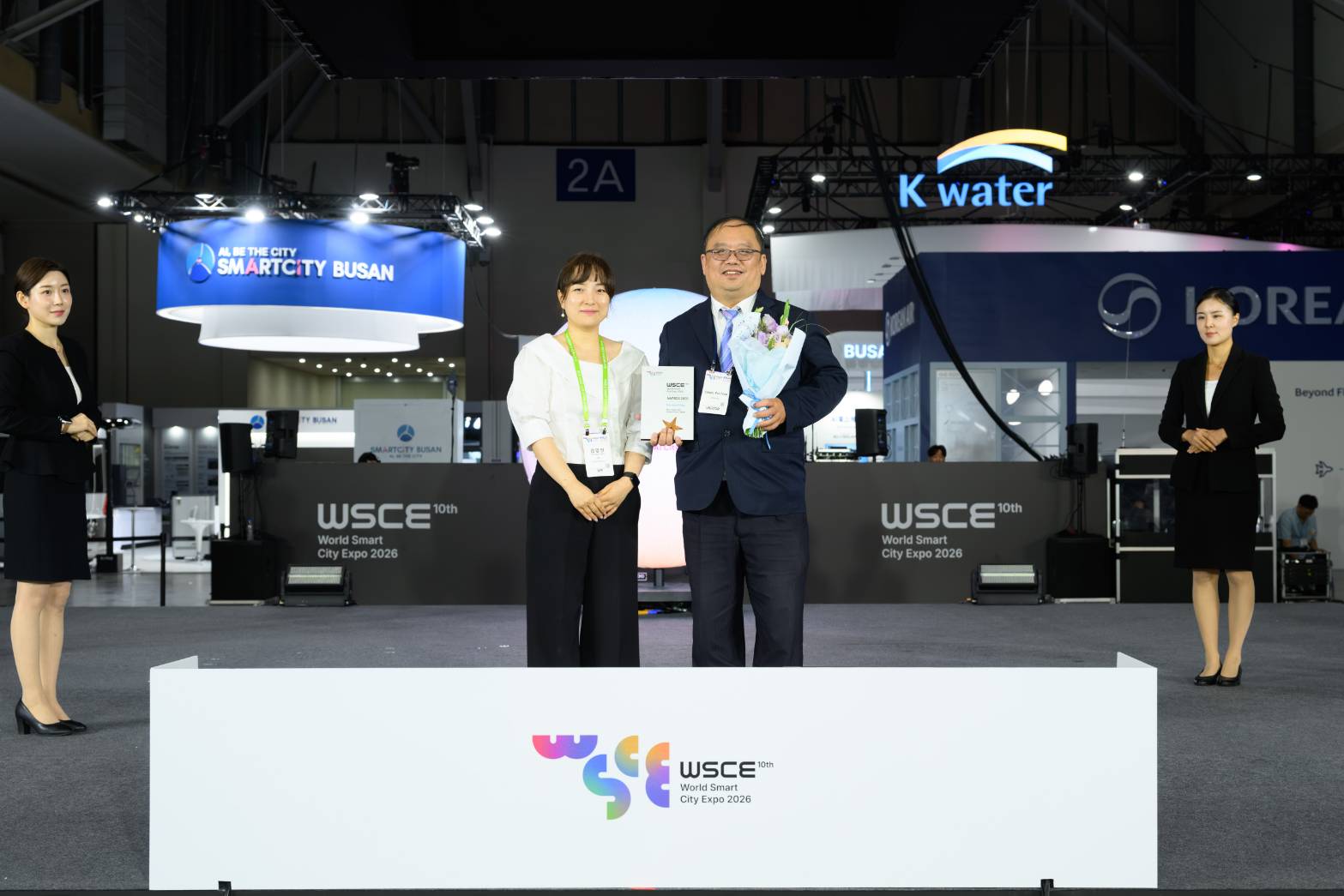 新北市政府出席韓國「WSCE 2026世界智慧城市博覽會暨頒獎典禮」，由世界智慧城市博覽會秘書長金伶仁(左)頒獎，資訊中心主任陳富添(右)代表領獎。