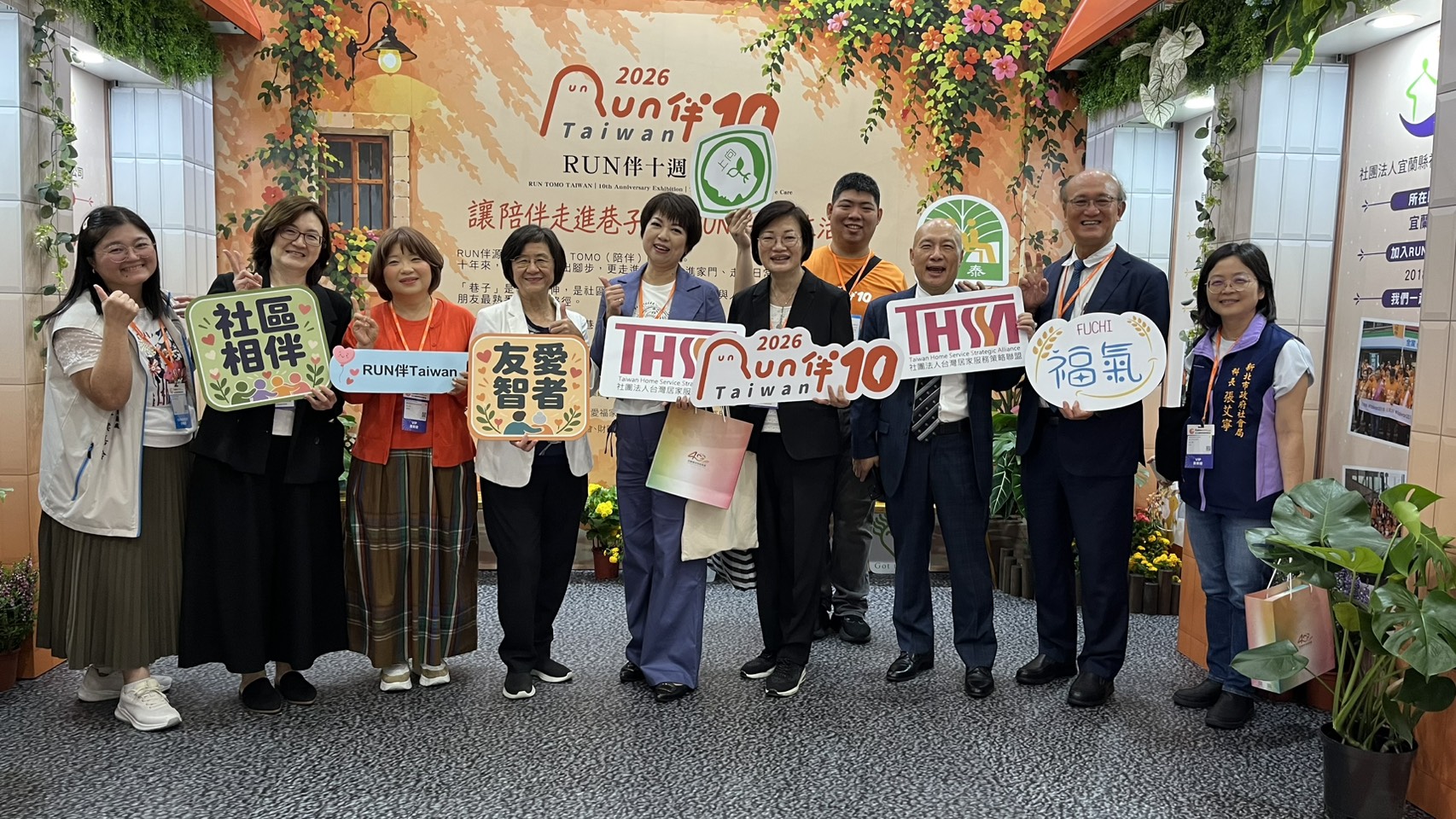  新北市府副秘書長龔雅雯（中）到新北市的據點攤位鼓勵 左四為衛生局長陳潤秋 右四為社會局長李美珍。