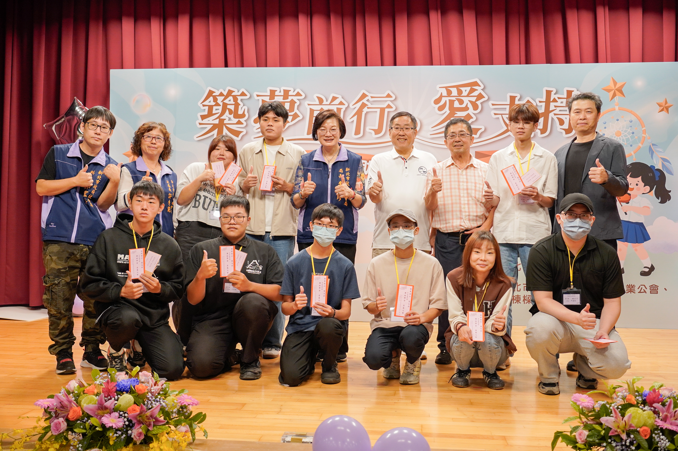 獎助學金由新北市社會局長李美珍(後排中)、新北市不動產開發商業同業公會理事長曹來春(後排右4)、常務理事張鑫榮(後排右3)共同進行頒贈。