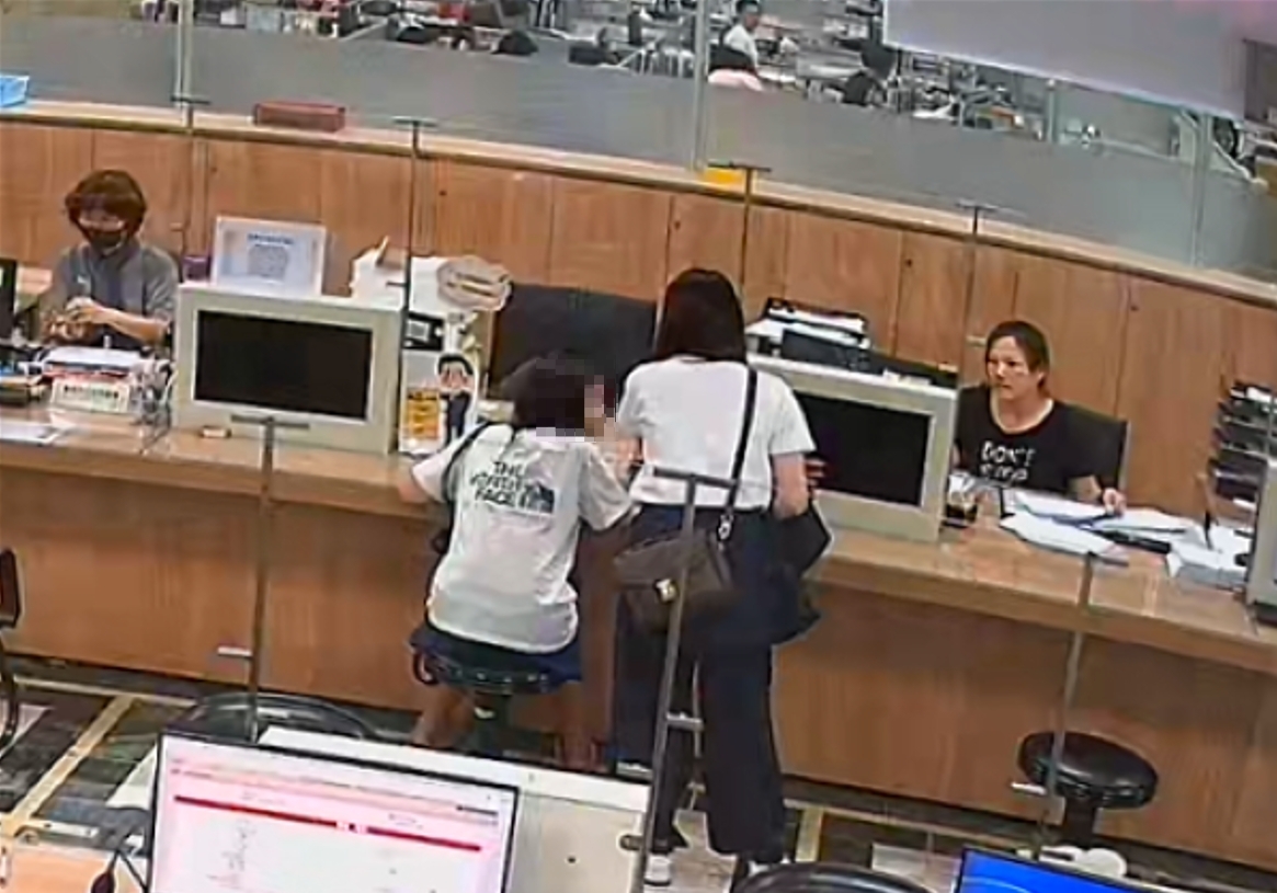  白衣女子(右)多次教導婦人回答地所人員的關懷提問。新北市地政局提供
