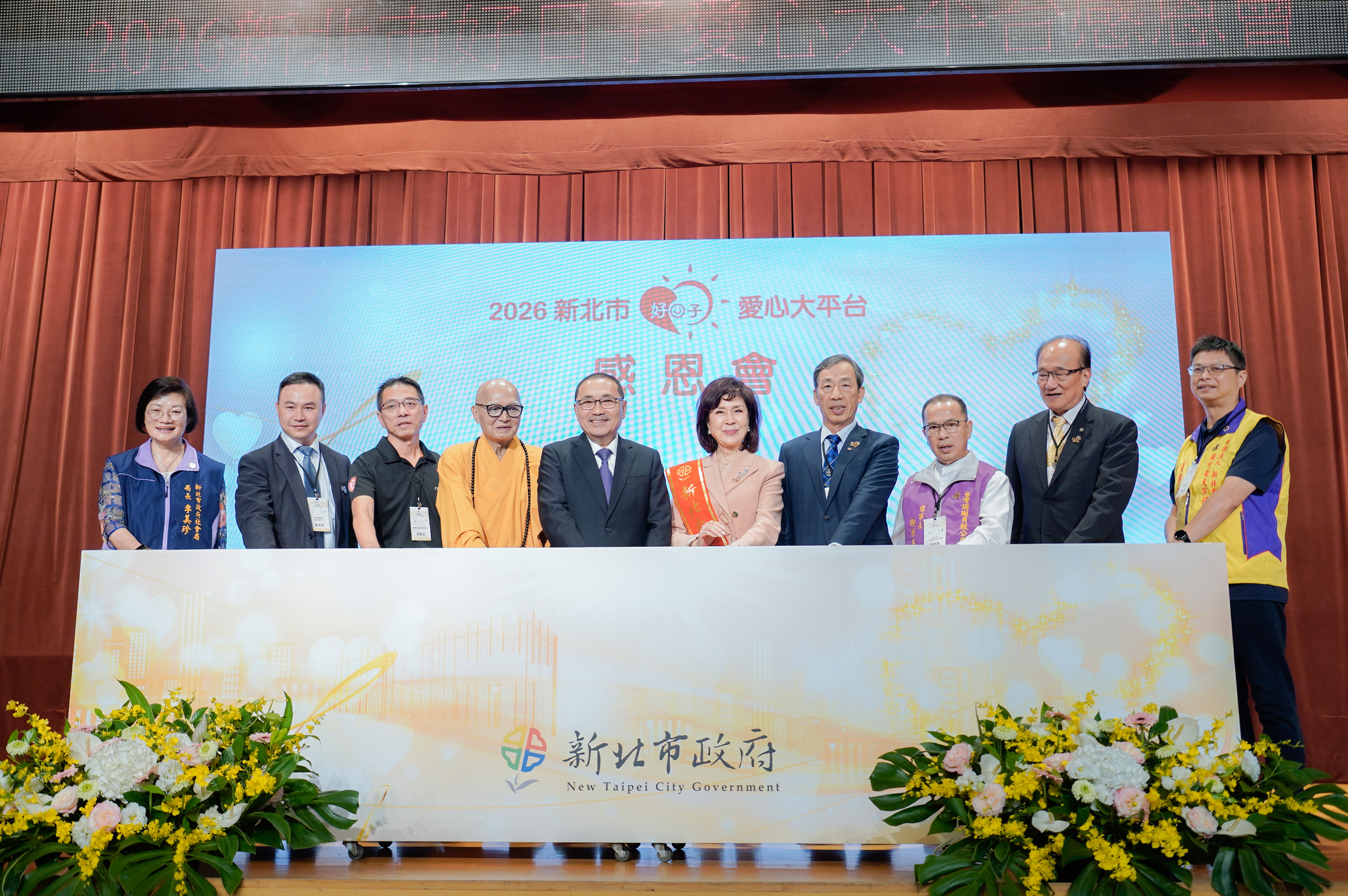 7位圓夢英雄代表和侯友宜市長、社會局長李美珍及愛心大使白嘉莉準備揭開7周年彩牌