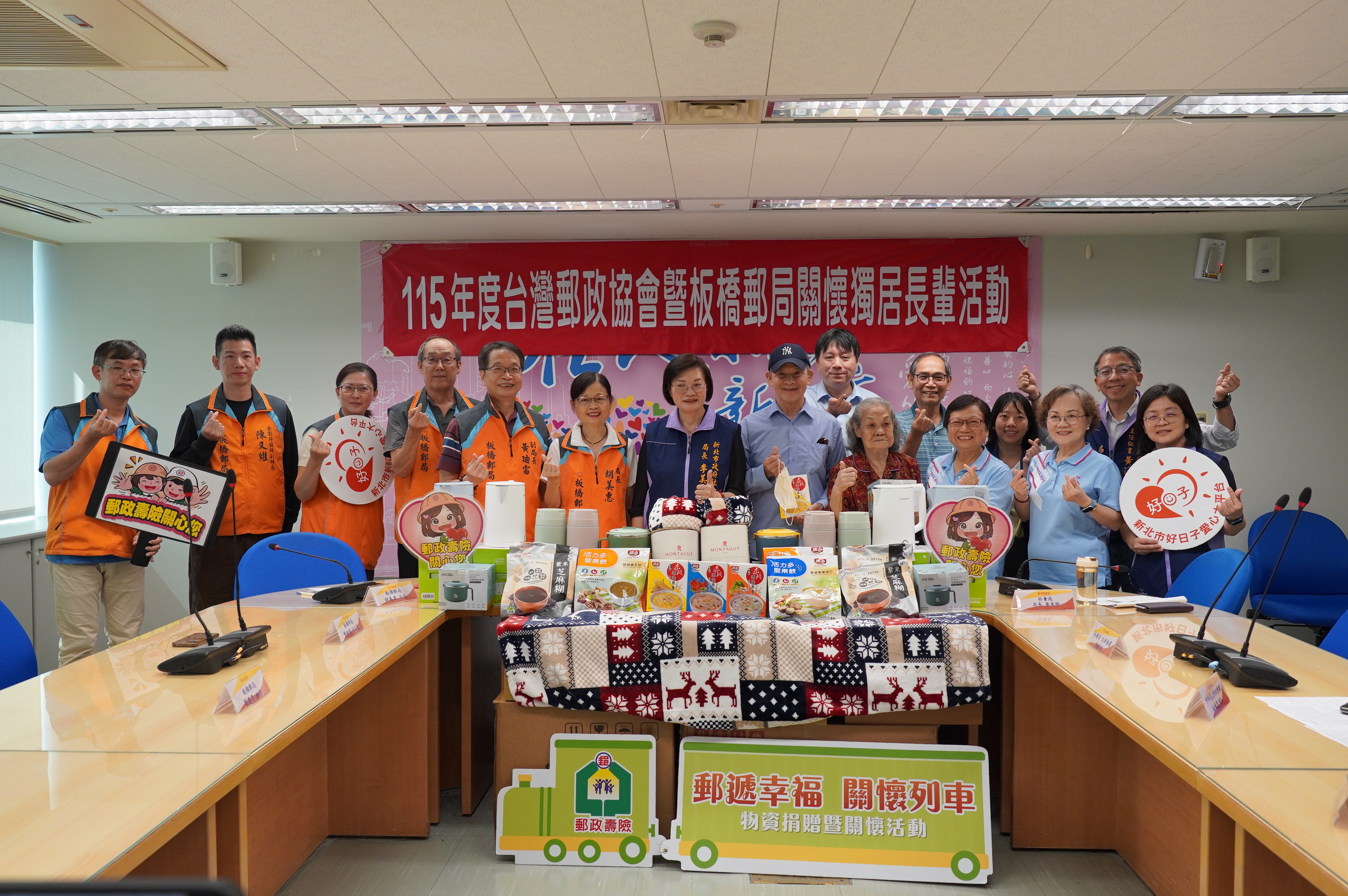  板橋郵局攜手台灣郵政協會捐贈物資，12日在新北社會局舉辦捐贈儀式。圖左6為板橋郵局長胡美惠、中為社會局長李美珍、右5及4為獨老代表劉爺爺及陳奶奶，後排右3為中和區公所社會課長林奉霆。